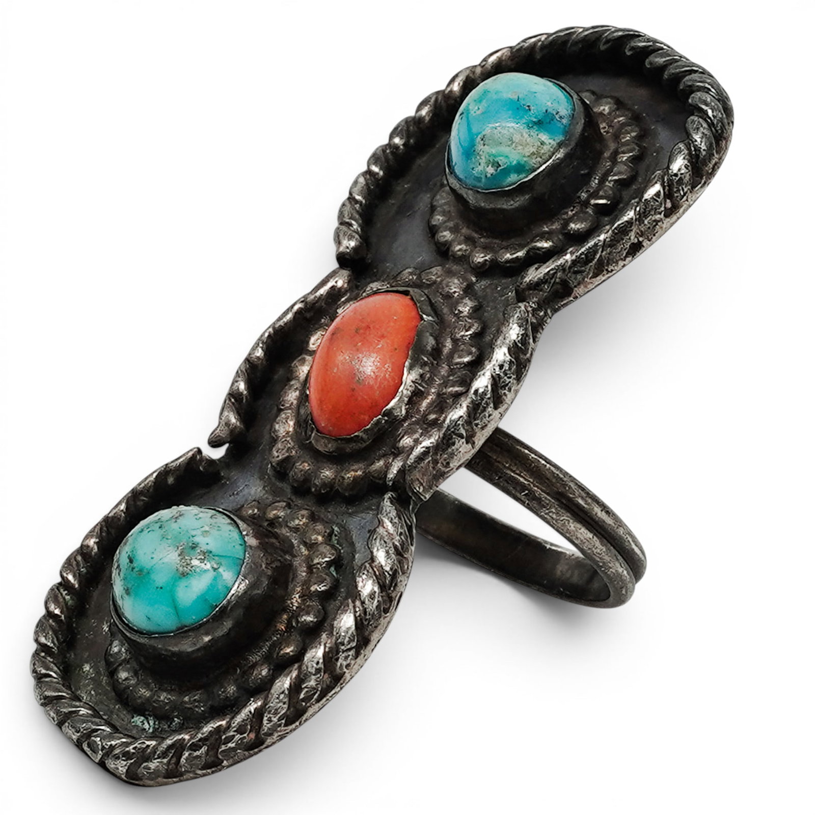 A Navajo Sterling Silver, Turquoise, And Coral Three-stone Ring: A Navajo sterling silver, turquoise, and coral three-stone ring Late 20th century Unmarked. Tested sterling silver. A vertical ring set with two turquoise cabochons flanking a central coral cabochon, 