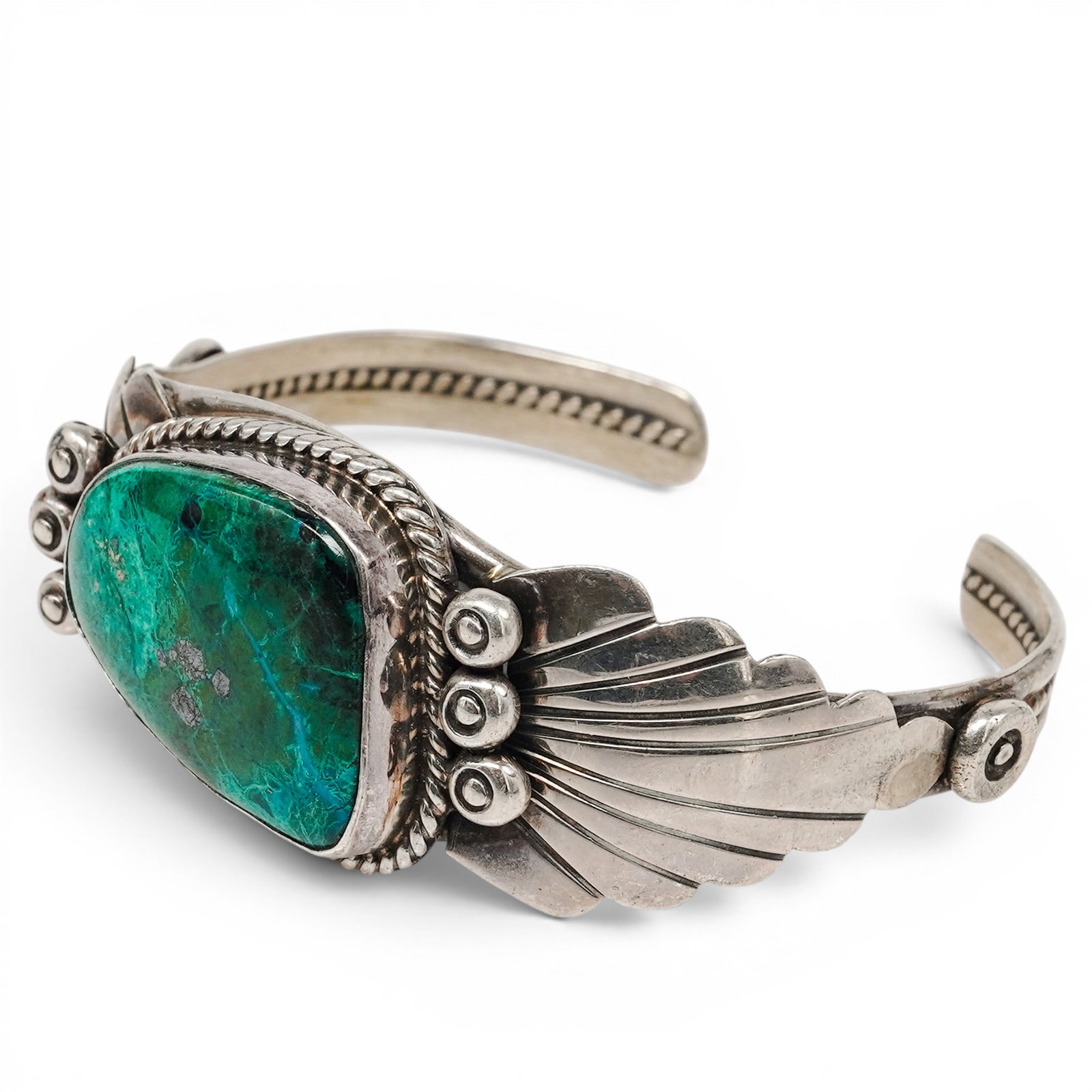 A Lee Thompson Navajo Sterling Silver And Green Turquoise Cuff Bracelet: A Lee Thompson Navajo sterling silver and green turquoise cuff bracelet Late 20th century Stamped: L.T. / Sterling. A cuff bracelet with a large triangular green turquoise cabochon in a rope wire beze