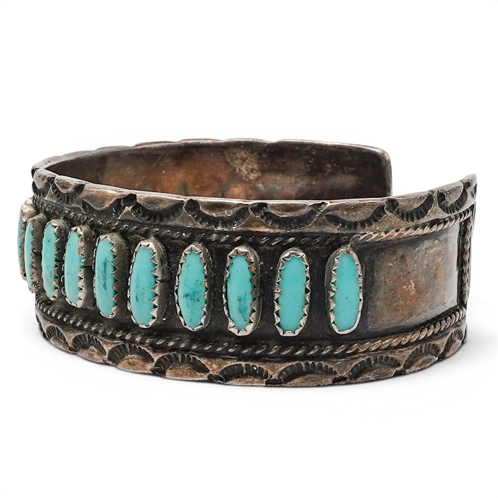 A Navajo Sterling Silver And Turquoise Needlepoint Cuff Bracelet: A Navajo sterling silver and turquoise needlepoint cuff bracelet Late 20th century Stamped: T.R., unidentified signature. Tested sterling silver. A cuff bracelet with a row of vertical needlepoint tur