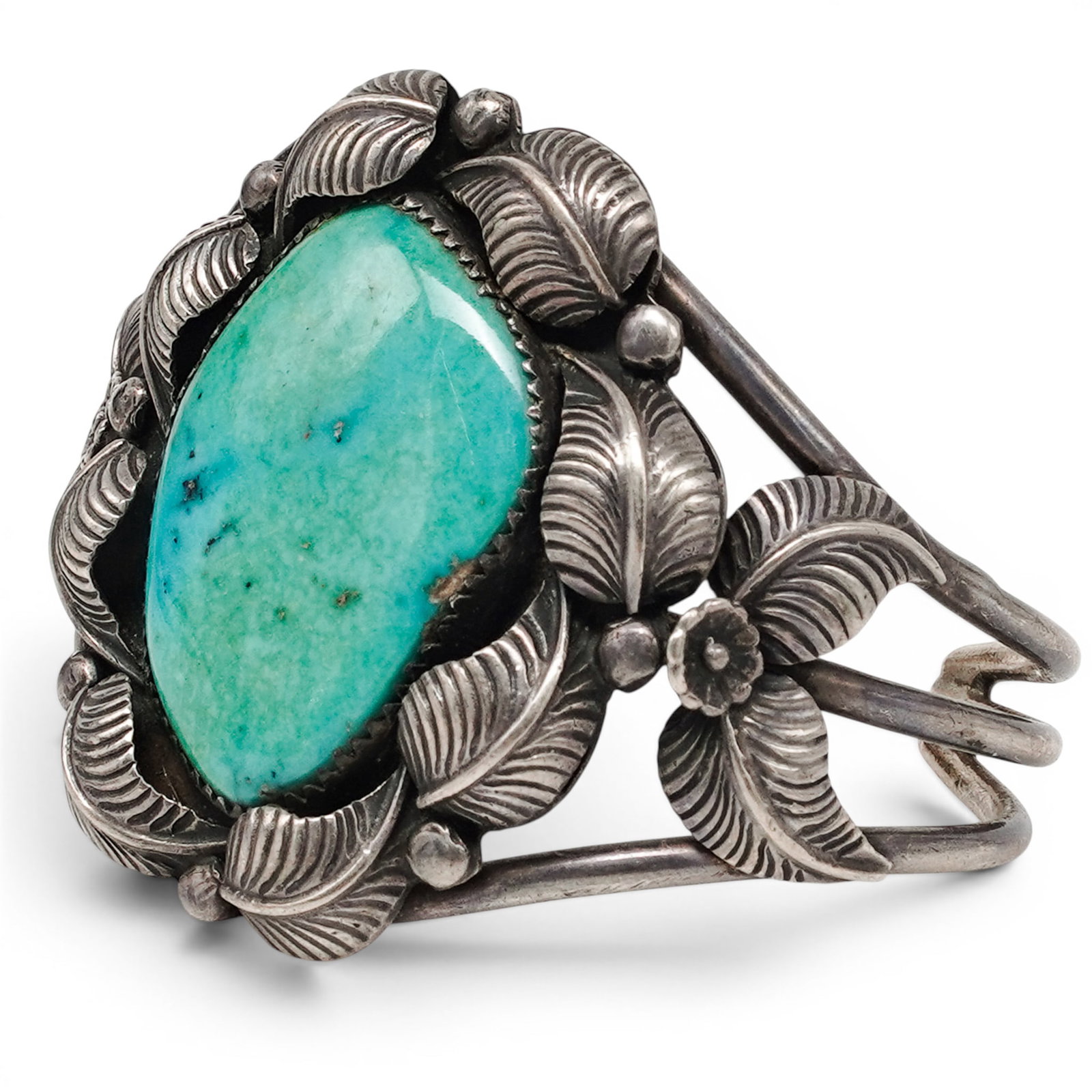 A Nila Cook Johnson Navajo Sterling Silver And Turquoise Leaf Form Cuff Bracelet: A Nila Cook Johnson Navajo sterling silver and turquoise leaf form cuff bracelet Late 20th century Stamped: N.J. Tested sterling silver. A substantial cuff bracelet centered by a large freeform turquo