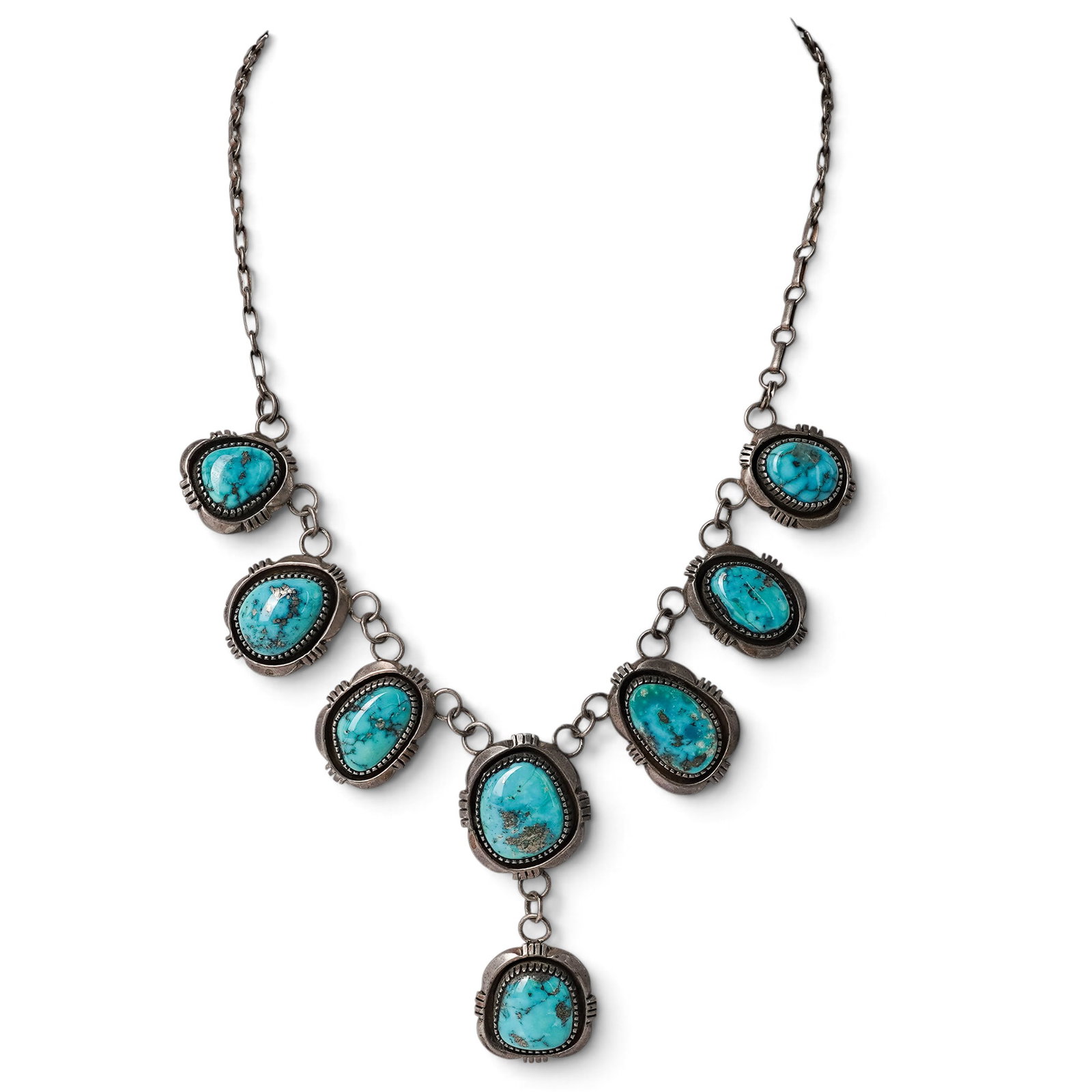 A Navajo Sterling Silver And Turquoise Cluster Link Necklace: A Navajo sterling silver and turquoise cluster link necklace Late 20th century Stamped: Sterling. A necklace with graduated bezel-set turquoise cabochon links in a cluster arrangement joined by chain 