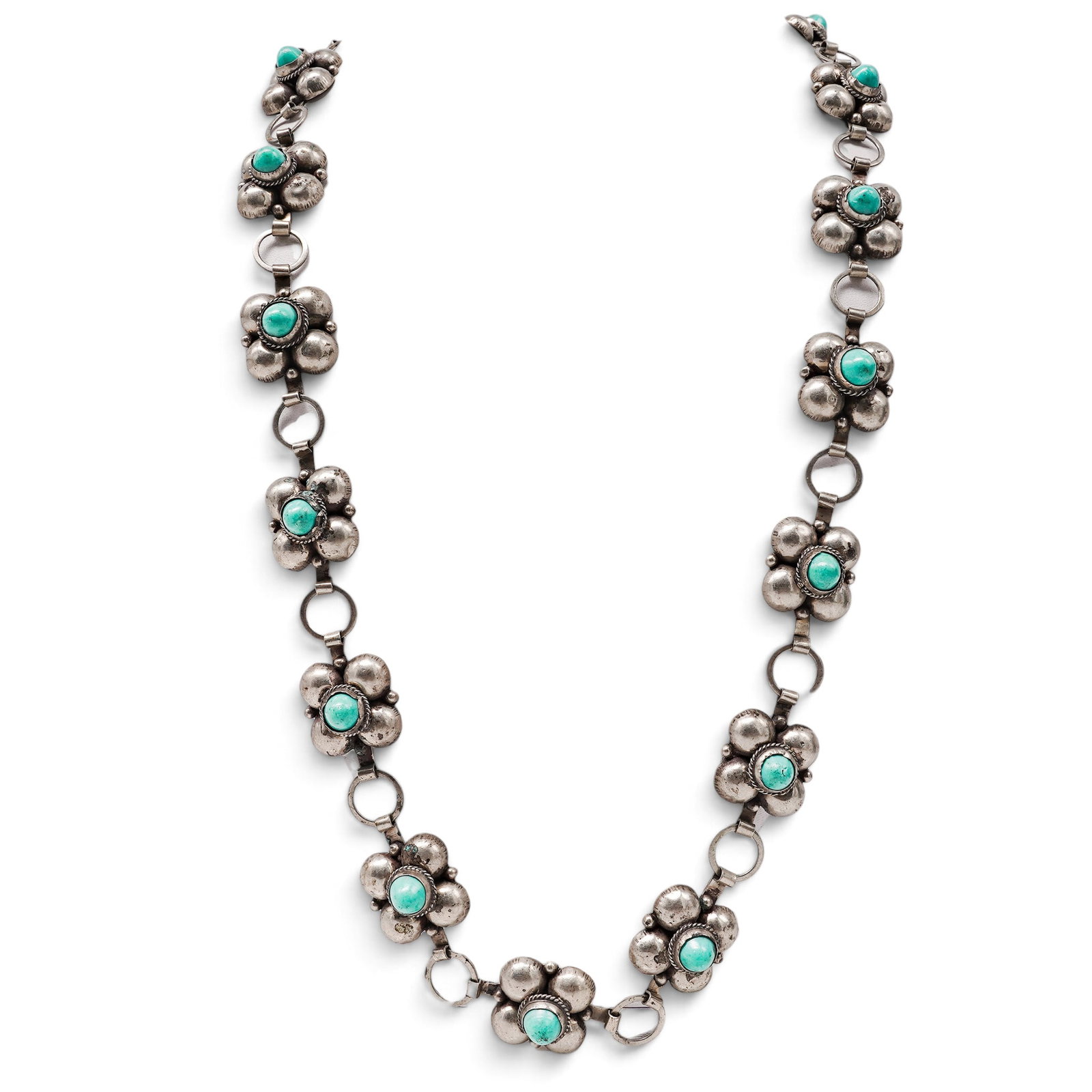 A Mexican Sterling Silver And Turquoise Blossom Link Necklace: A Mexican sterling silver and turquoise blossom link necklace Late 20th Century Stamped: Mexico / Sterling. A necklace composed of repeating flower-form links set with turquoise cabochons in bezels, j