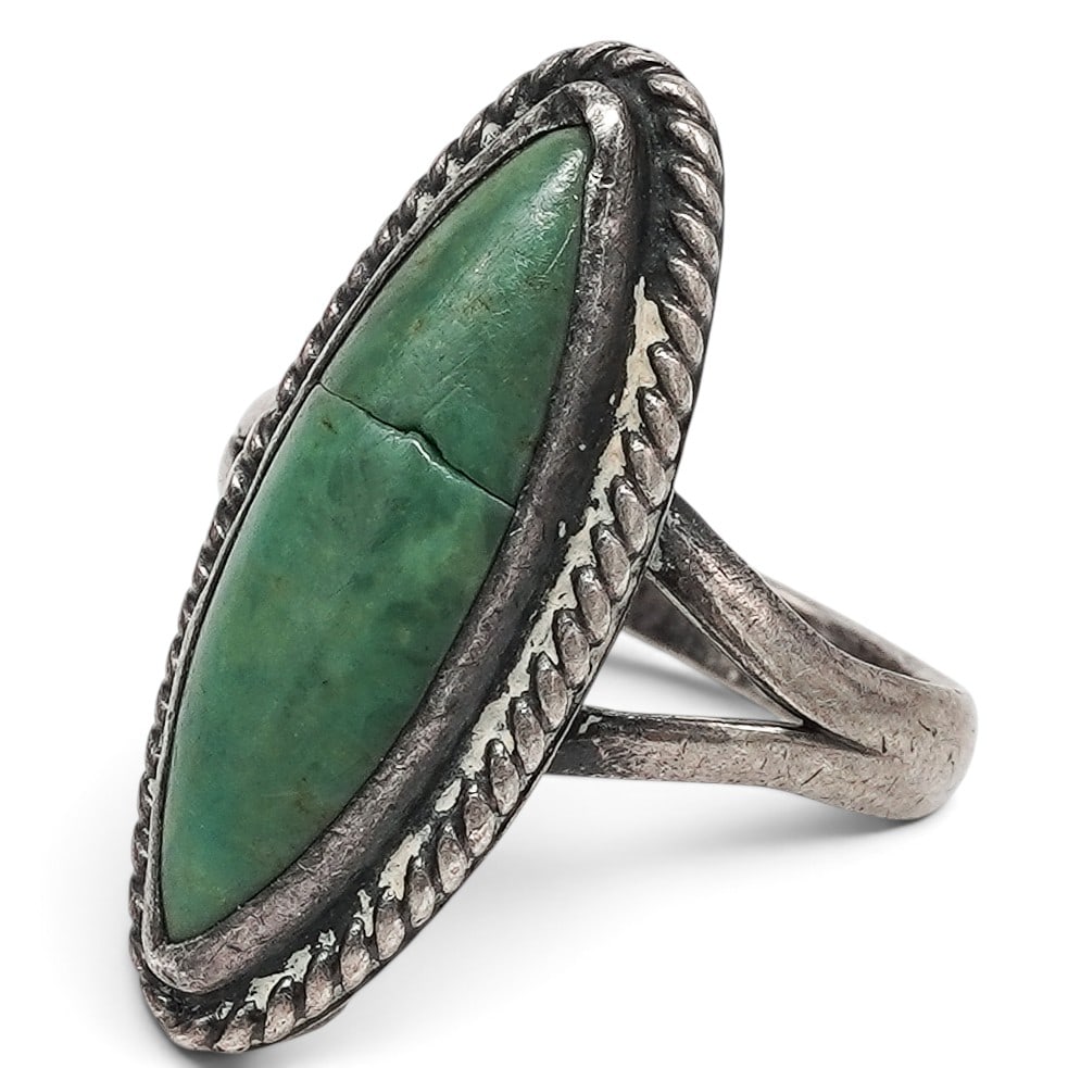A Mexican Sterling Silver And Green Turquoise Ring: A Mexican sterling silver and green turquoise ring Late 20th century Stamped: G.C.01 / .925. A ring with an elongated marquise-shaped green turquoise cabochon in a bezel setting with rope-twist border