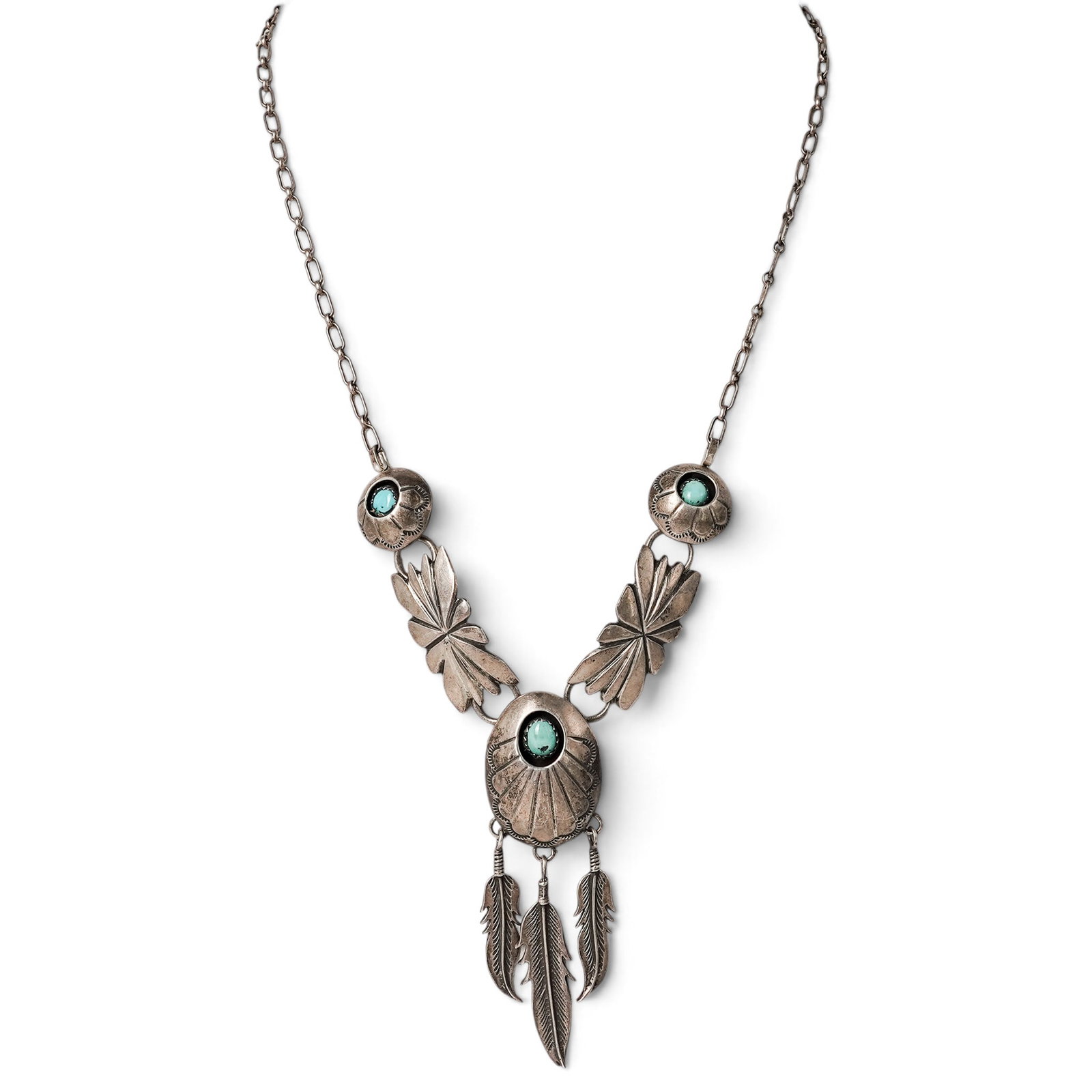 A Navajo Sterling Silver And Turquoise Concho Feather Pendant Necklace: A Navajo sterling silver and turquoise concho feather pendant necklace Late 20th century Unmarked. Tested sterling silver. A necklace centered by a concho-form pendant with three feather drops and thr