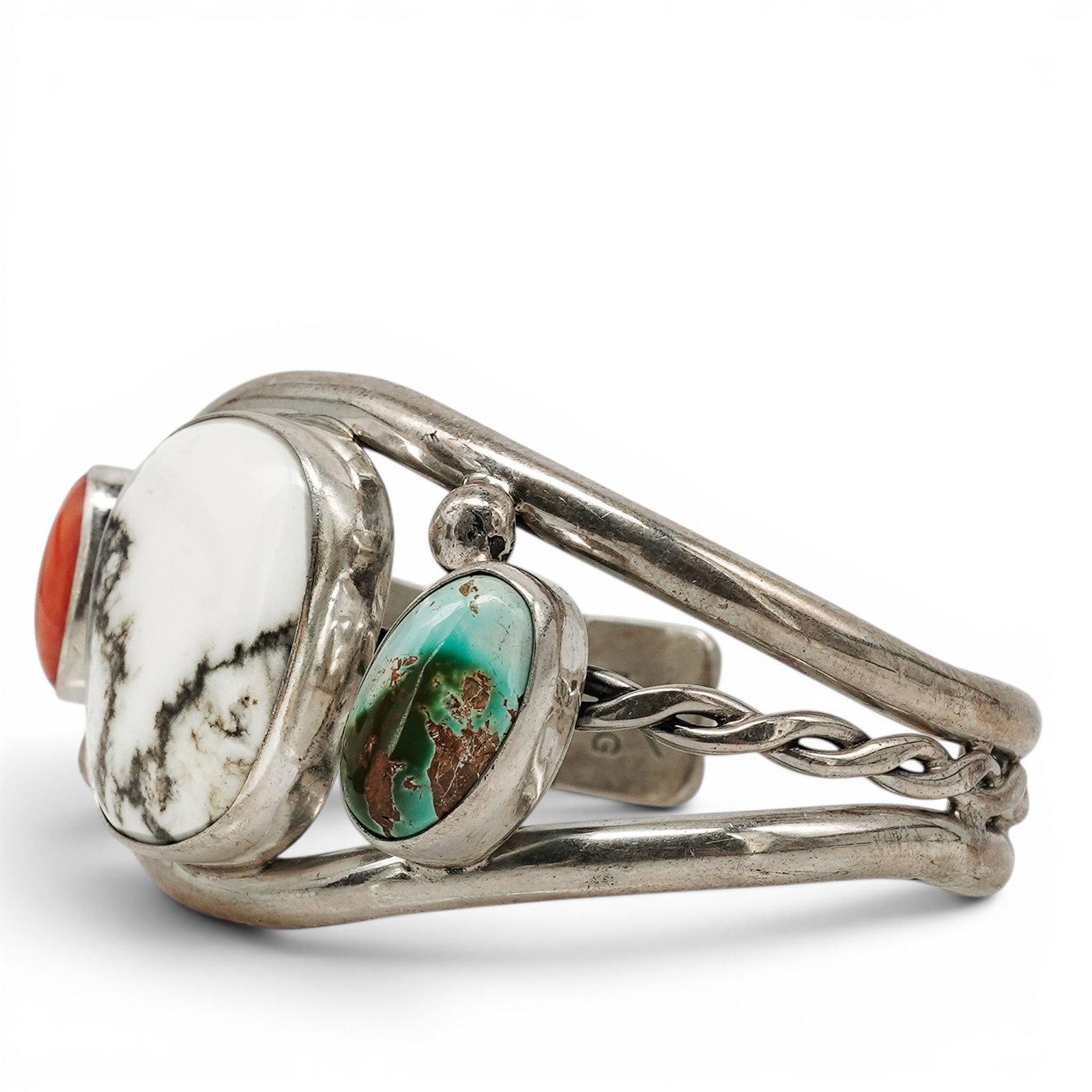 A Nelson Garcia Kewa Sterling Silver And Multistone Cuff Bracelet: A Nelson Garcia Kewa sterling silver and multistone cuff bracelet Late 20th Century Stamped: N.G. / Sterling A cuff bracelet set with a large oval white buffalo stone flanked by coral and turquoise ca