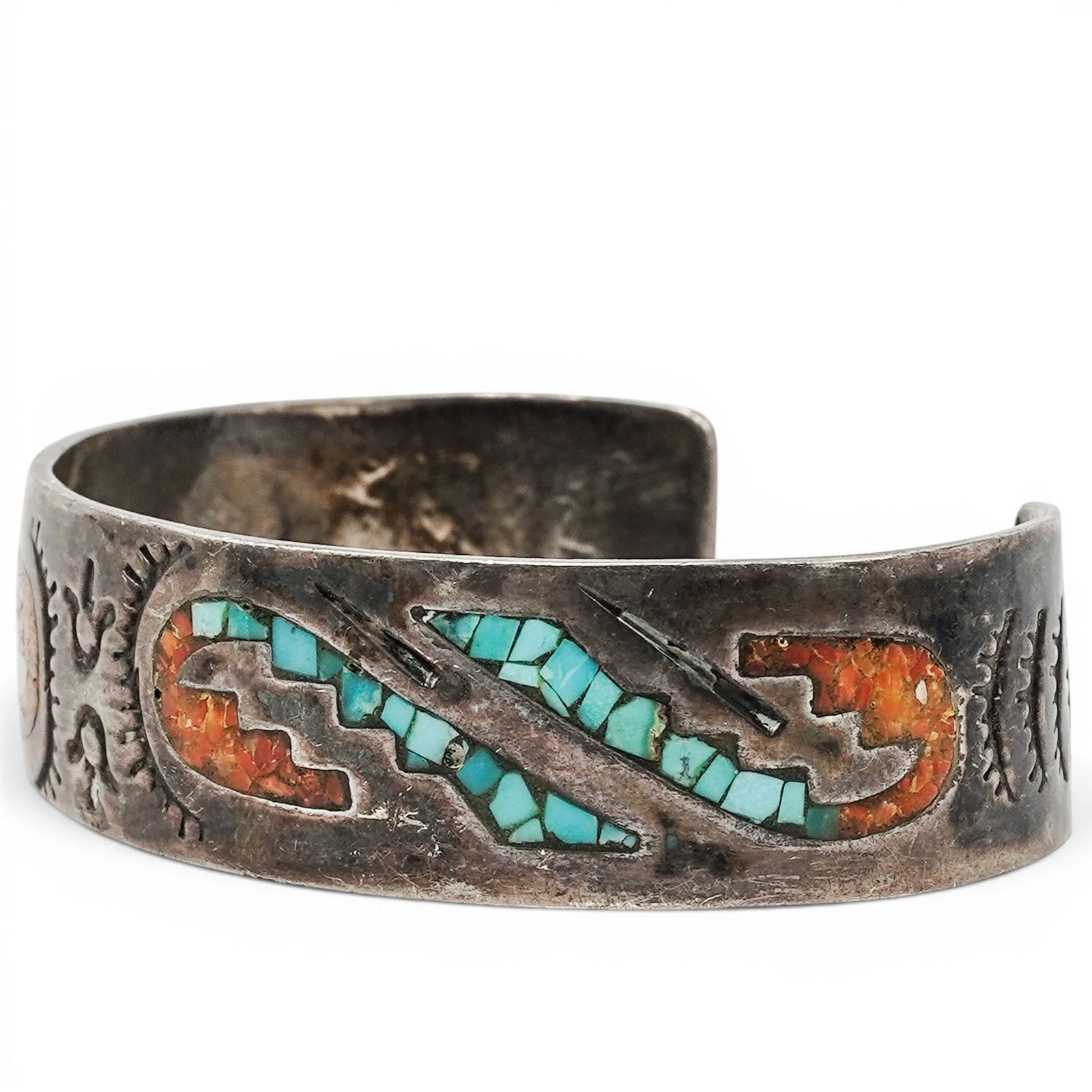 A Navajo Sterling Silver, Turquoise, And Coral Chip Inlay Cuff Bracelet: A Navajo sterling silver, turquoise, and coral chip inlay cuff bracelet Late 20th Century Stamped: Unidentified makers mark. Tested sterling silver. A tapered cuff bracelet with turquoise and coral ch