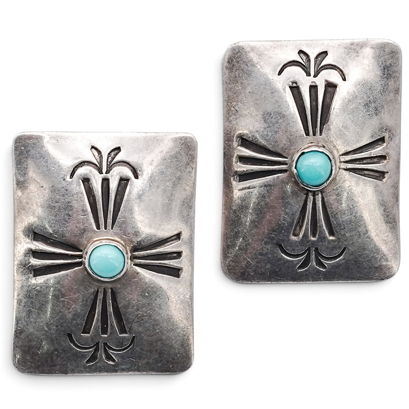 A Pair Of Navajo Sterling Silver And Turquoise Stamped Clip Earrings: A pair of Navajo sterling silver and turquoise stamped clip earrings Late 20th century Stamped: A.N.M., unidentified signature / Sterling. Rectangular clip earrings with cutout geometric motifs center
