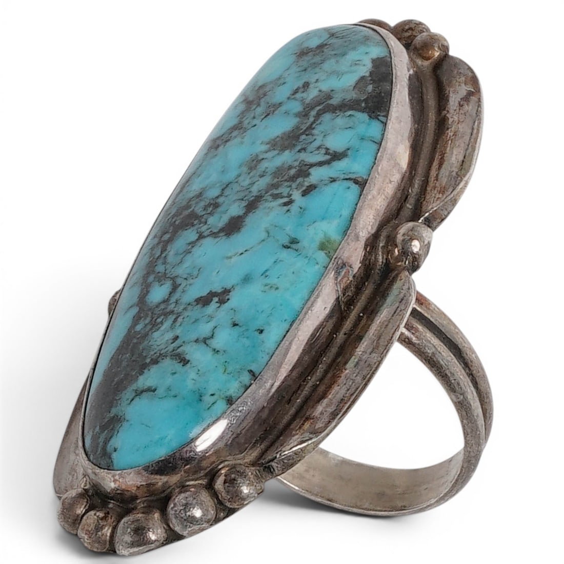 A Rosalina Francisco Navajo Sterling Silver And Turquoise Ring: A Rosalina Francisco Navajo sterling silver and turquoise ring Late 20th century Stamped: R.F. / Sterling A large elongated oval turquoise cabochon in a serrated bezel mount, accented with applied