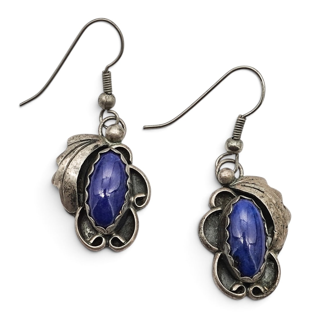 A Pair Of Fannie Sanchez Navajo Sterling Silver And Lapis Lazuli Scrollwork Dangle Earrings: A pair of Fannie Sanchez Navajo sterling silver and lapis lazuli scrollwork dangle earrings Late 20th Century Stamped: P. FNE-STG. Tested sterling silver. Each with an oval lapis lazuli cabochon in a 