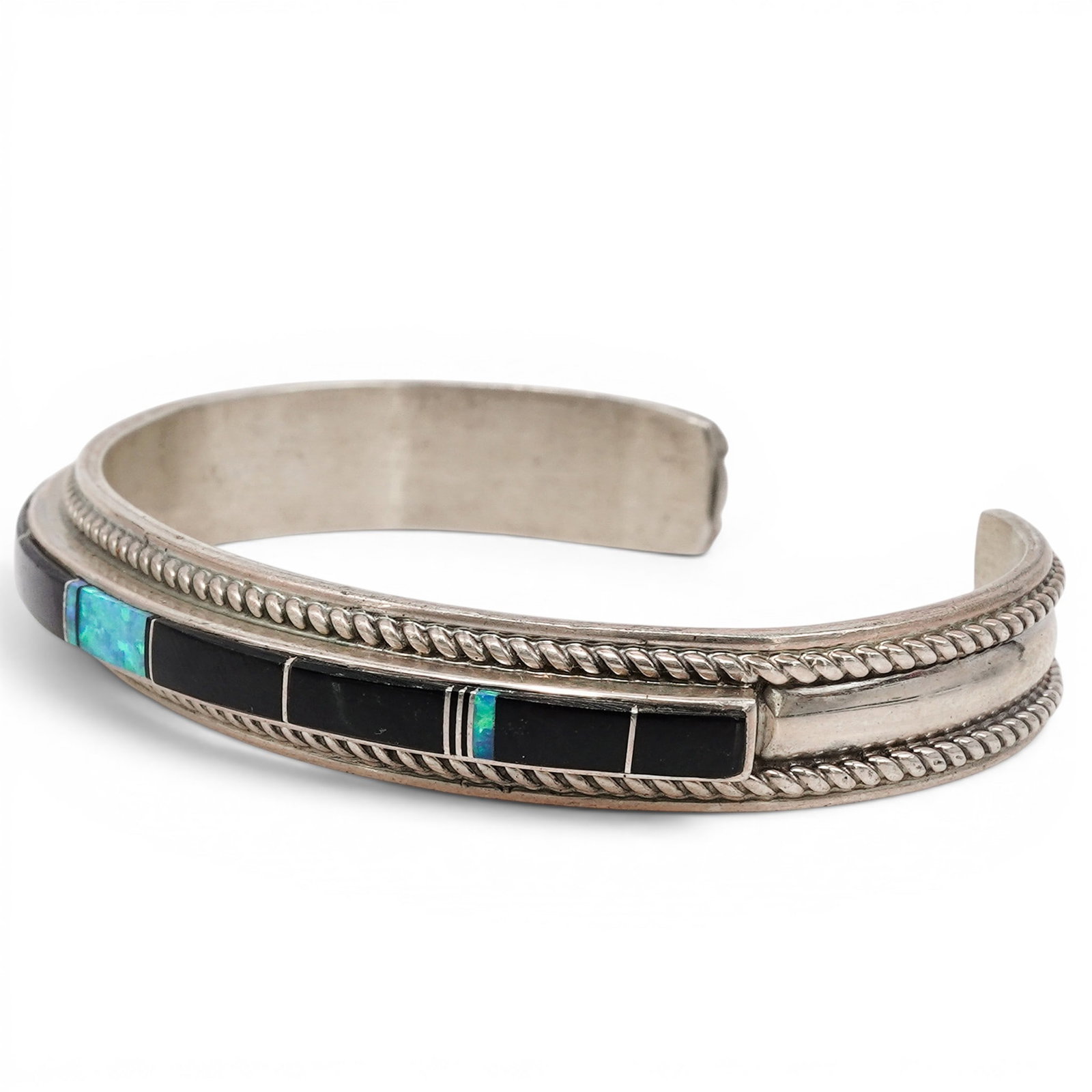 A Thomas Francisco Navajo Sterling Silver, Onyx, And Turquoise Stone Inlay Cuff Bracelet: A Thomas Francisco Navajo sterling silver, onyx, and turquoise stone inlay cuff bracelet Late 20th century Stamped: T.F. / Sterling. A tapered cuff bracelet with channel inlay comprising of onyx and