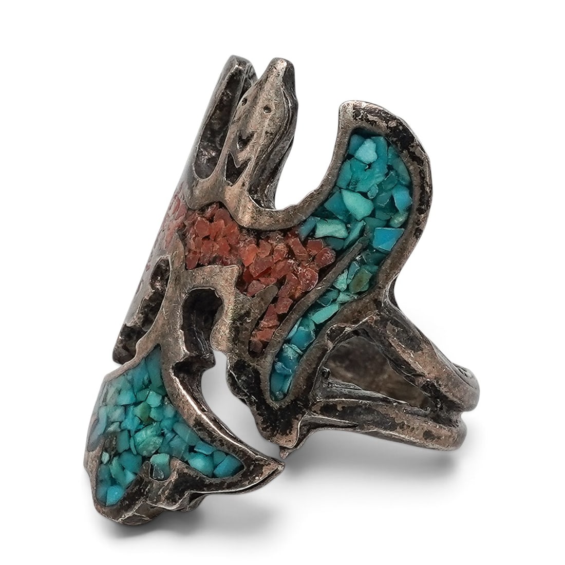 A Navajo Sterling Silver, Turquoise, And Coral Figural Chip Inlay Ring: A Navajo sterling silver, turquoise, and coral figural chip inlay ring Late 20th century Unmarked. Tested sterling silver. A ring with a bird-form top decorated with turquoise and coral chip inlay wit