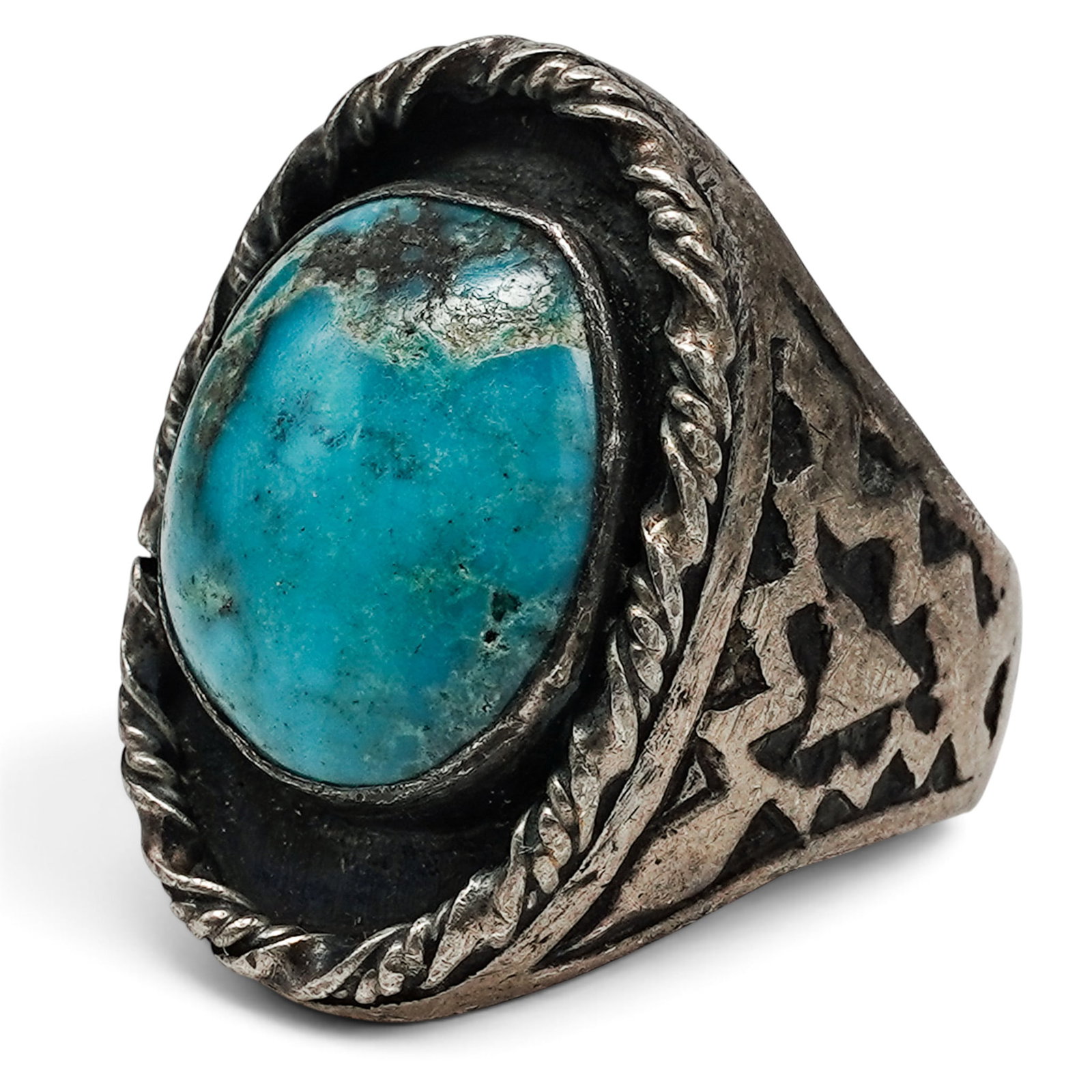 A Navajo Sterling Silver And Turquoise Stampwork Ring: A Navajo sterling silver and turquoise stampwork ring Late 20th century Stamped: .925. A substantial ring with a large oval bezel-set turquoise cabochon, rope wire border, and heavily stamped shoulder