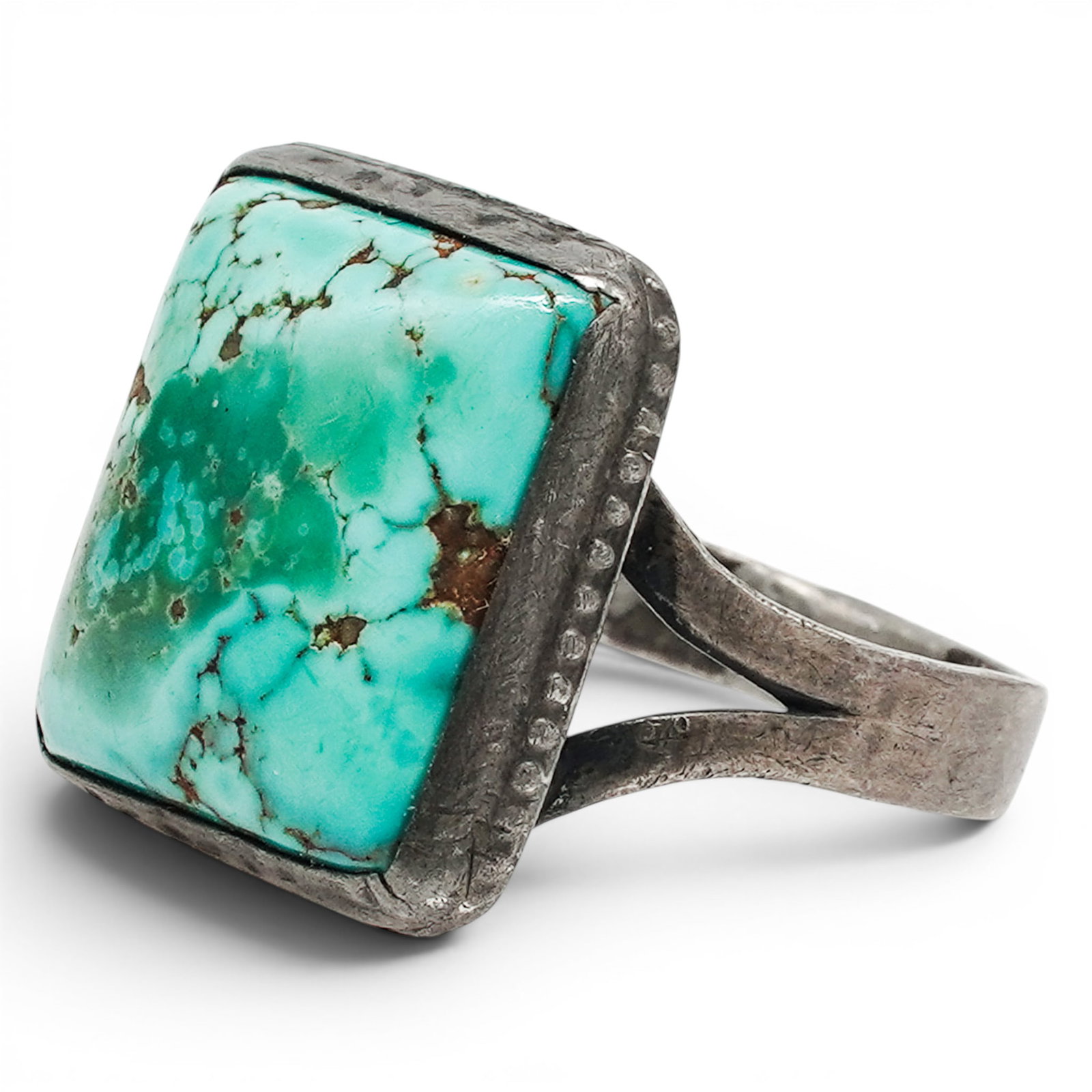 A Navajo Sterling Silver And Square Turquoise Cabochon Ring: A Navajo sterling silver and square turquoise cabochon ring Late 20th century Unmarked. Tested sterling silver. A ring set with a square turquoise cabochon with light matrix in a plain bezel mount on 