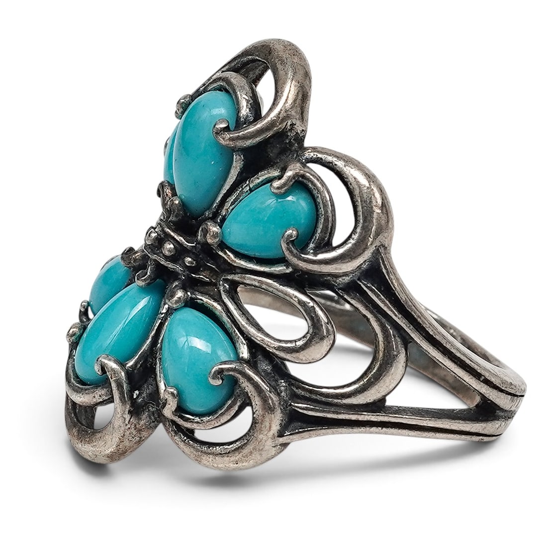 A Carolyn Pollack For Relios Sterling Silver And Turquoise Ring: A Carolyn Pollack for Relios sterling silver and turquoise ring Late 20th Century Stamped: C.P. / Relios hallmark / .925. A ring with six turquoise cabochons in serrated bezels, accented by applied be