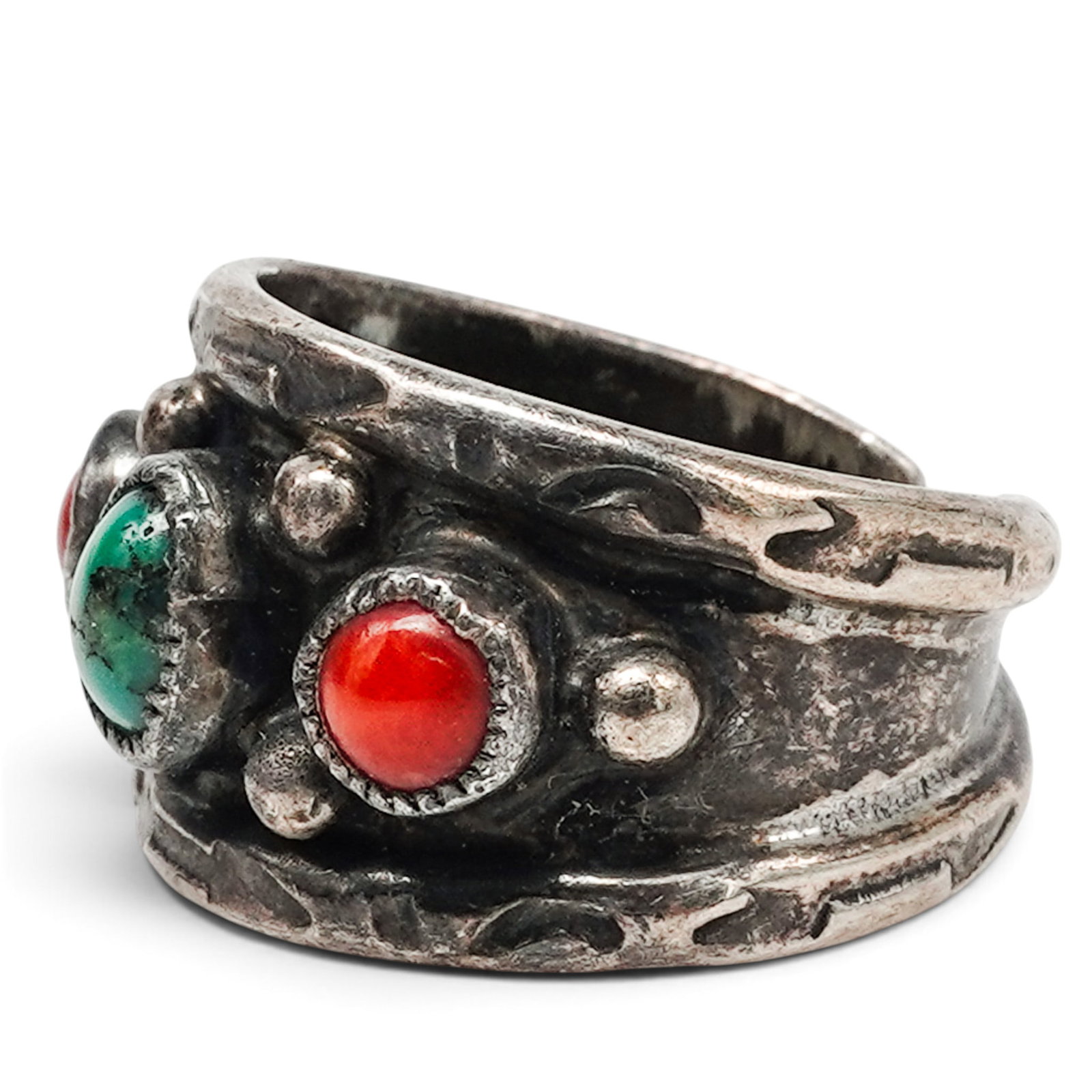 A Navajo Sterling Silver, Green Turquoise, And Coral Three-stone Ring: A Navajo sterling silver, green turquoise, and coral three-stone ring Late 20th century Unmarked. Tested sterling silver. A wide silver band ring with central bezel-set green turquoise cabochon flanke