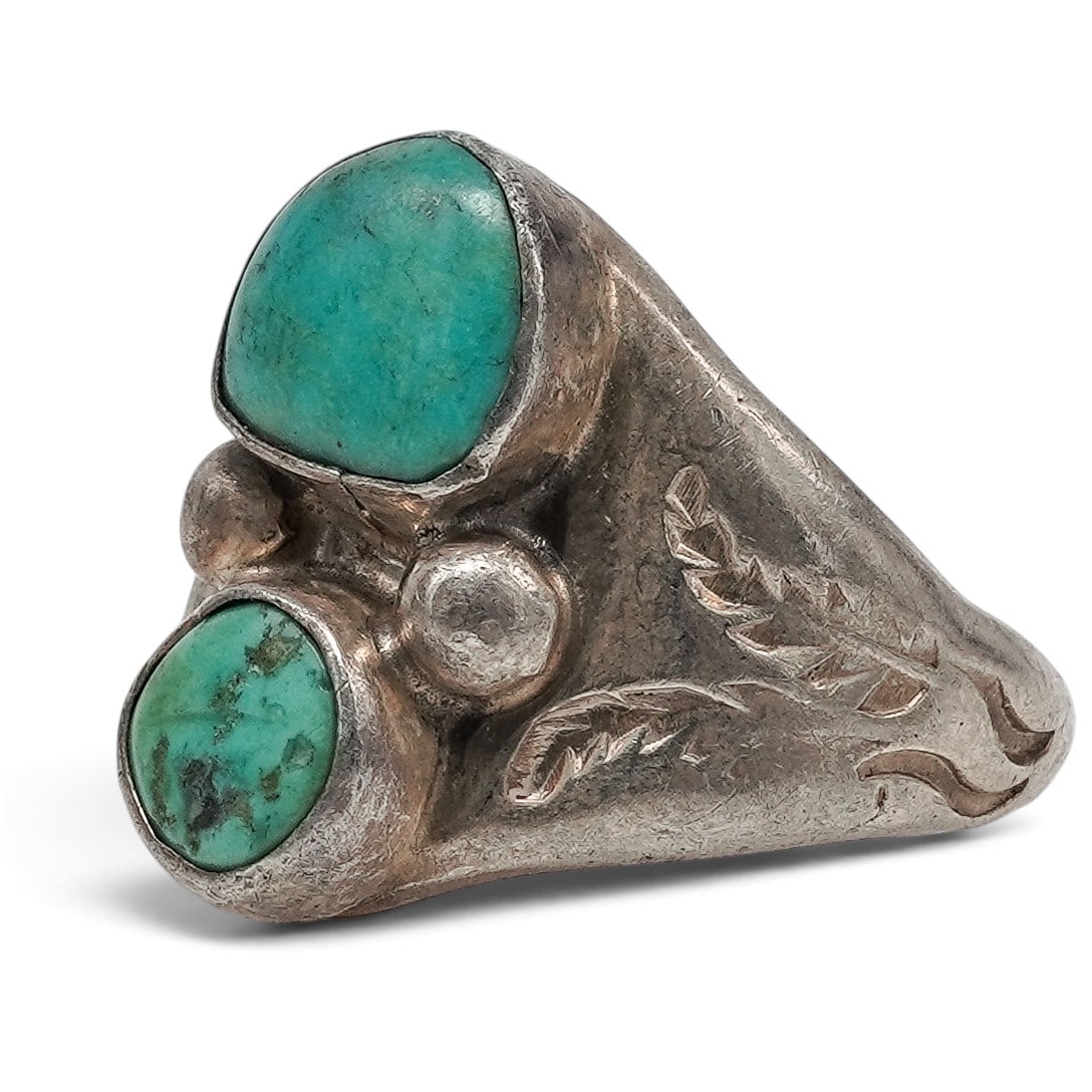A Navajo Sterling Silver And Turquoise Two-stone Ring: A Navajo sterling silver and turquoise two-stone ring Late 20th century Stamped: E.L., unidentified maker. Tested sterling silver. A wide tapered ring with two bezel-set turquoise cabochons in graduat