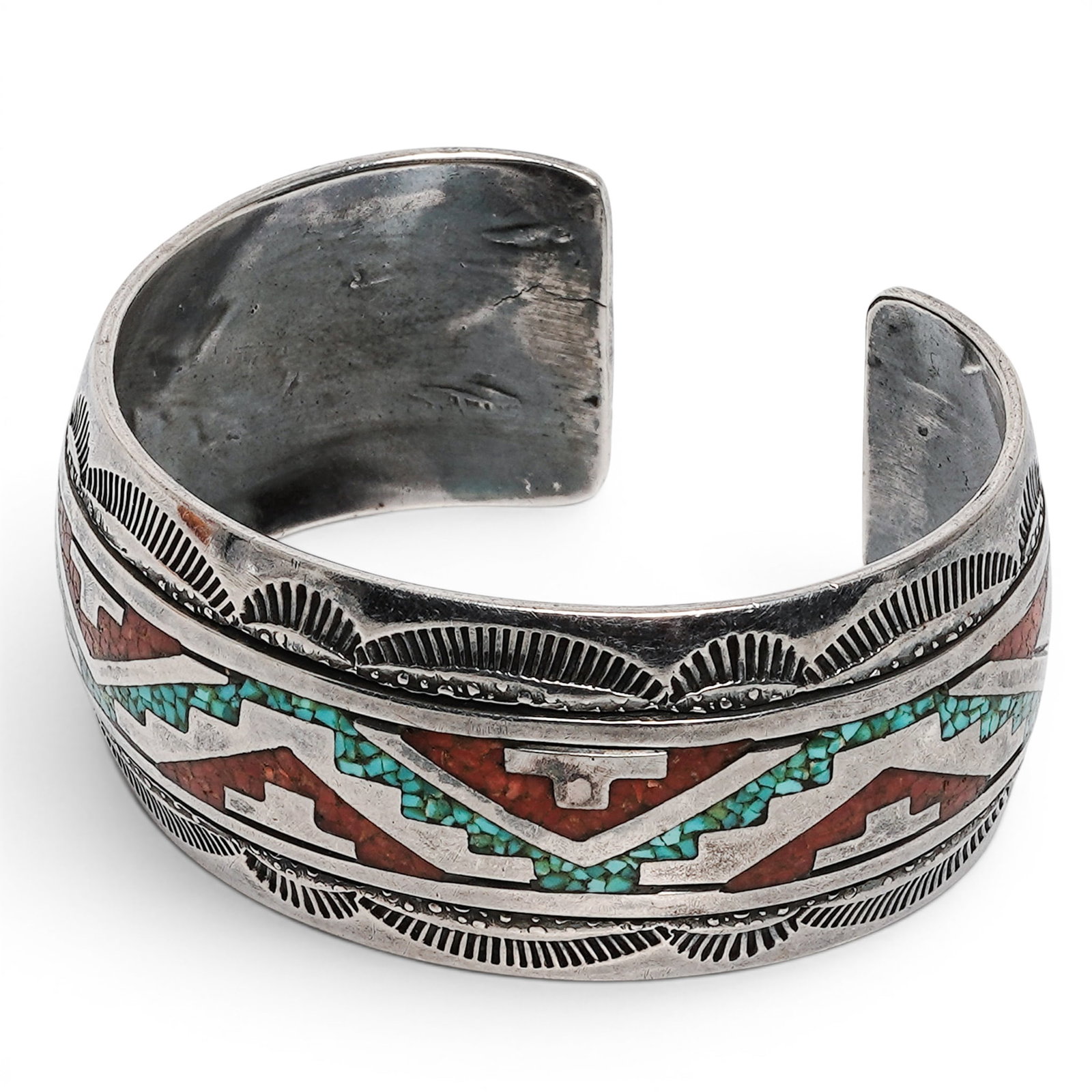 A Thomas Singer Navajo Sterling Silver, Turquoise, And Coral Chip Inlay Cuff Bracelet: A Thomas Singer Navajo sterling silver, turquoise, and coral chip inlay cuff bracelet Late 20th century Stamped: T with pictorial hallmark. Tested sterling silver. A wide sterling silver cuff bracelet