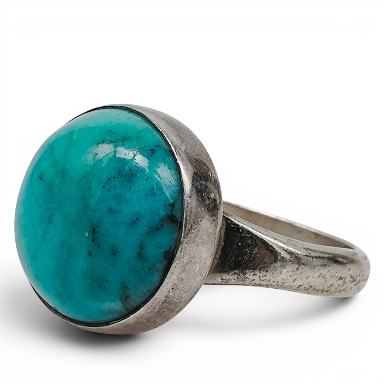 A Mitchell Calabaza Kewa Silver And Turquoise Cabochon Ring: A Mitchell Calabaza Kewa silver and turquoise cabochon ring Late 20th century Stamped: MCLBZ / Sterling A ring set with a large oval turquoise cabochon in a bezel mount on a wide tapered sterling silv