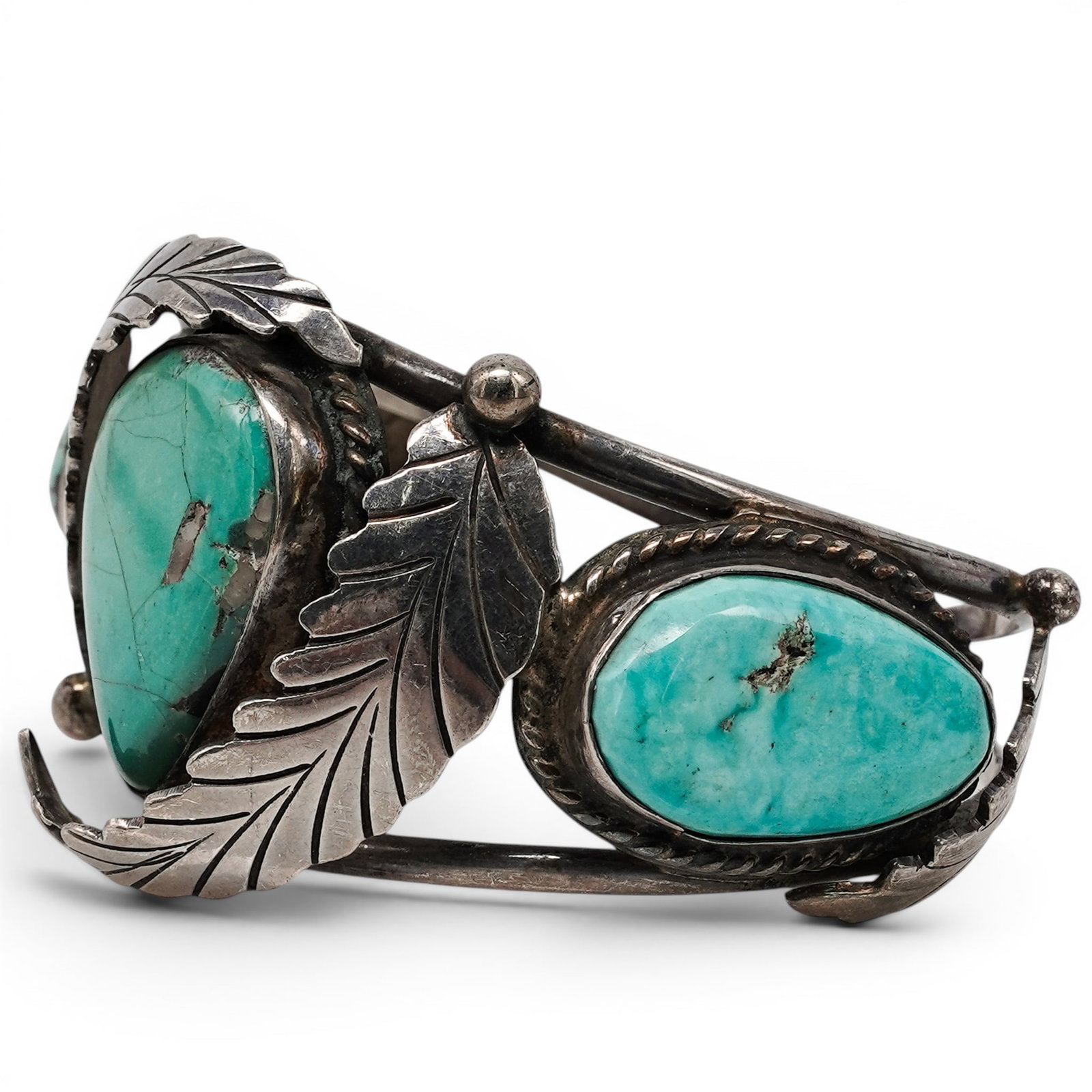 A Navajo Sterling Silver And Turquoise Feather Cuff Bracelet: A Navajo sterling silver and turquoise feather cuff bracelet Late 20th century Stamped: Unidentified signature. Tested sterling silver. A split shank cuff bracelet set with three polished turquoise ca