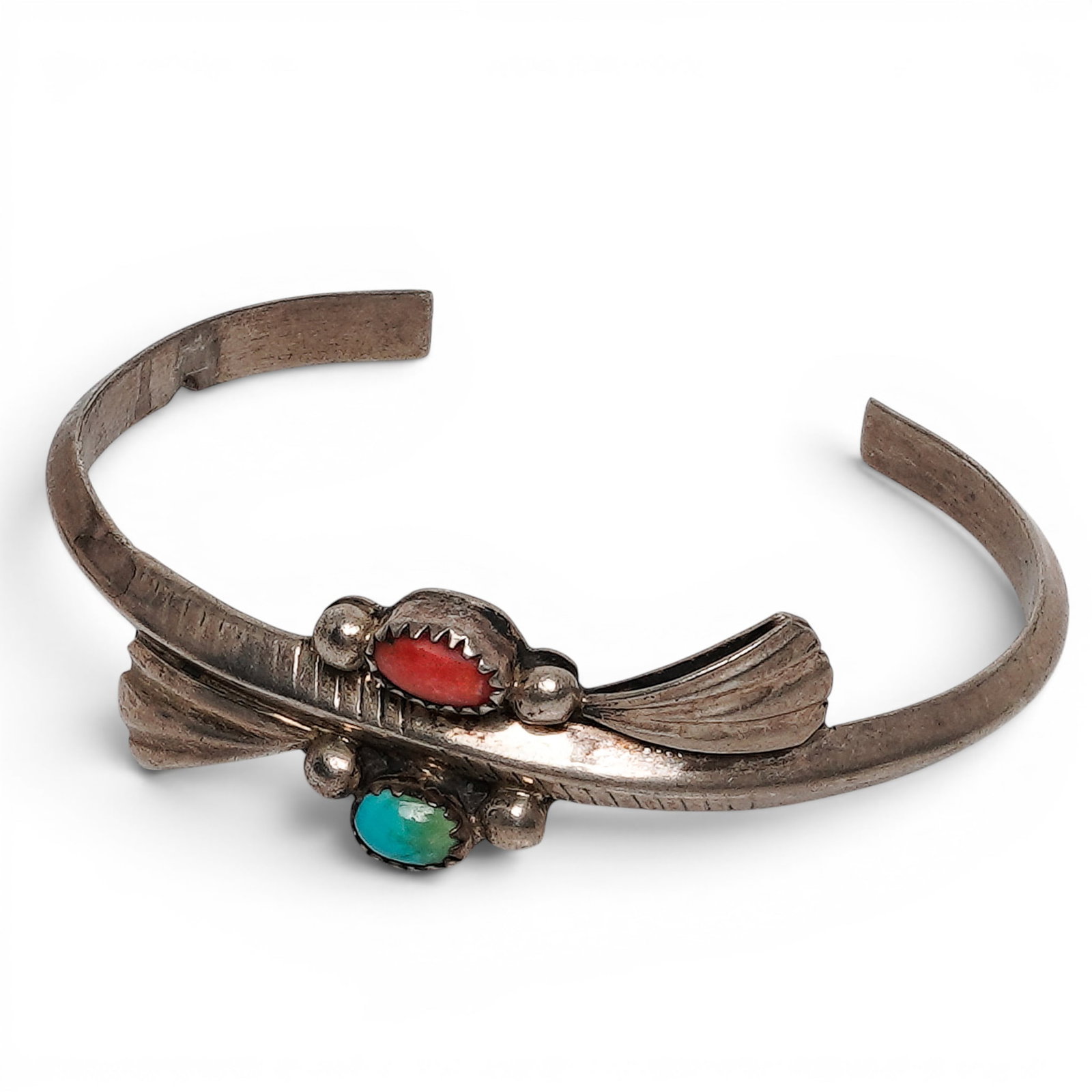 A Harry Plummer Navajo Sterling Silver, Turquoise, And Coral Two Stone Cuff Bracelet: A Harry Plummer Navajo sterling silver, turquoise, and coral two stone cuff bracelet Late 20th century Stamped: H. Plummer. Tested sterling silver. A tapered cuff bracelet set with oval coral and turq