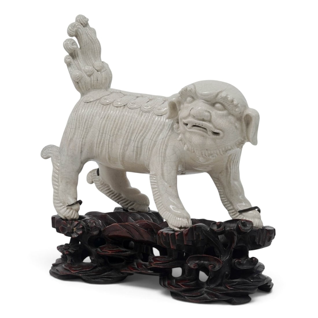 Chinese White Crackle Glaze Porcelain Buddhist Lion: Chinese White Crackle Glaze Porcelain Buddhist Lion 18th-19th century, Chinese A Chinese white crackle glaze porcelain Buddhist lion on original carved wood stand. Lion features a curling mane,
