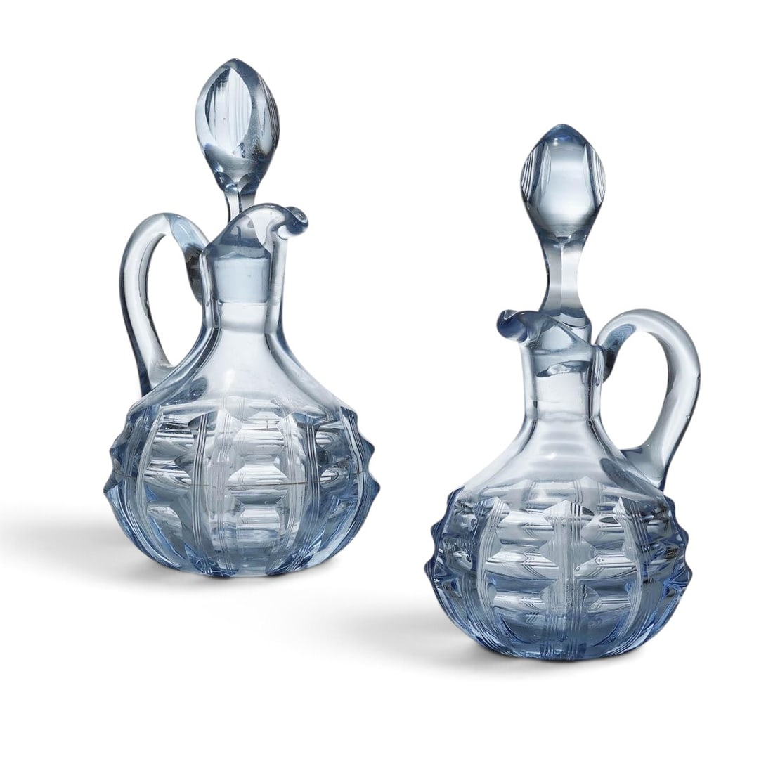 Pair Blue Pressed Glass Cruets: Pair Blue Pressed Glass Cruets 20th Cent, USA Pair of light blue glass cruets, with block optic style patterns on lower half of bowl. Accompanied with matching glass stoppers. H 7 3/4" x W 3 1/4"