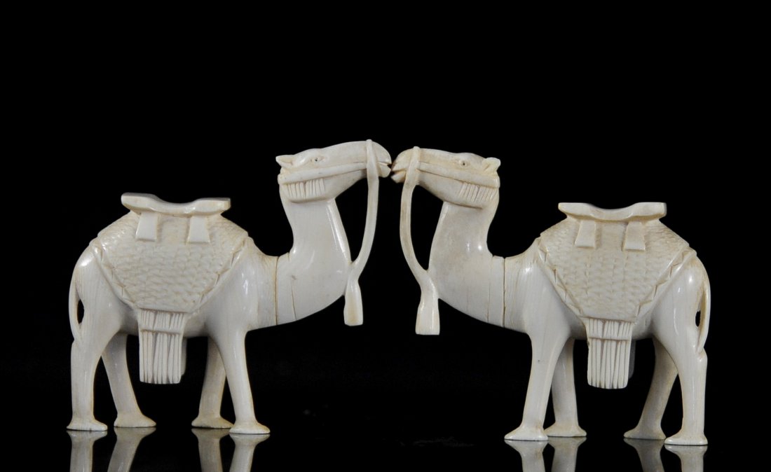 Antique Pair Of Hand Carved Ivory Camels: DESCRIPTION: Pair of hand carved ivory camels finely dressed. CIRCA: Early 20th ct ORIGIN: Africa DIMENSIONS: H:3.5" L:4" each