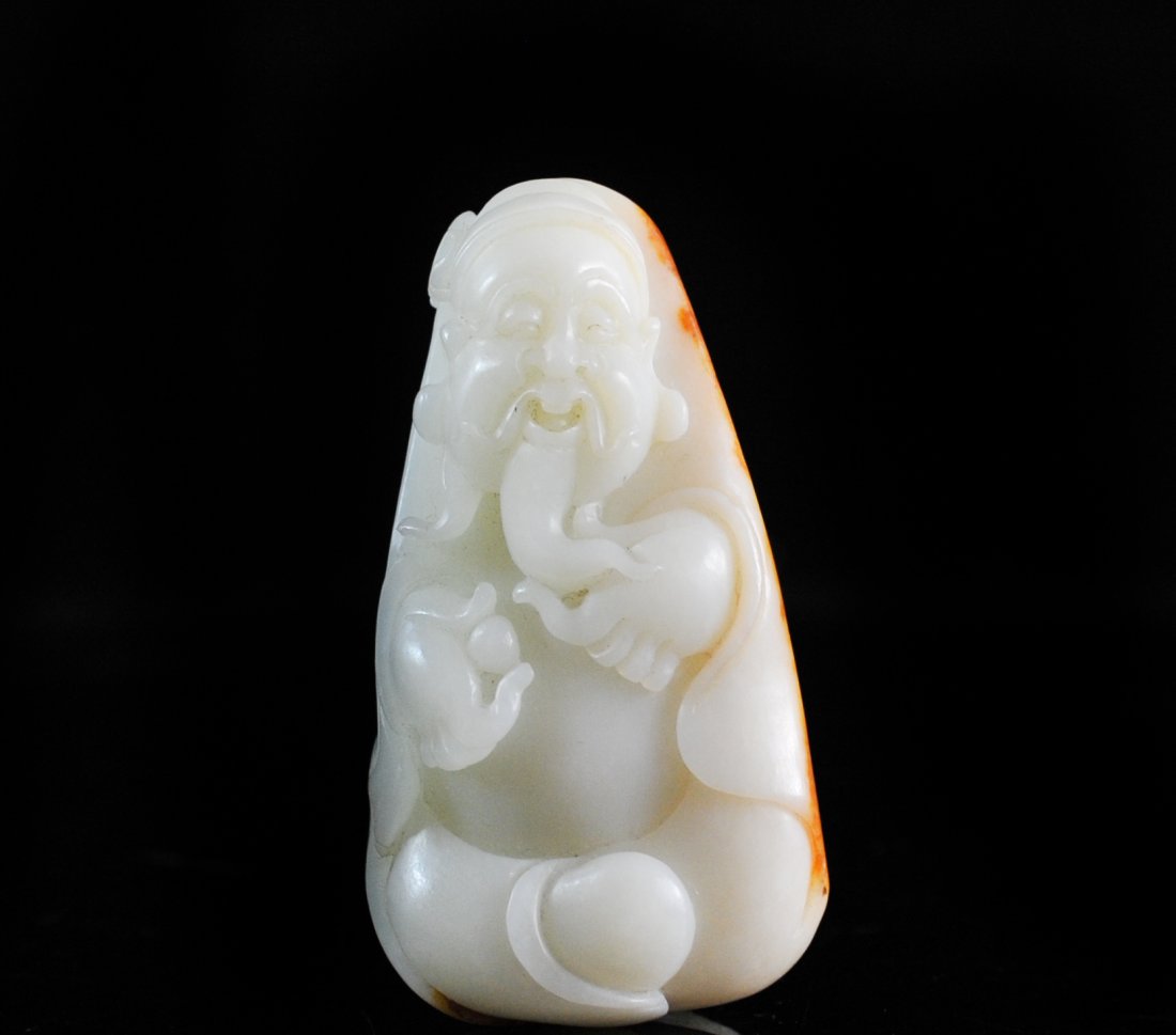 Chinese Hand Carved White Jade Toggle: DESCRIPTION: White jade hand carved toggle of oval silhouette, featuring a bearded beggar. Deep relief carving with phenomenal detail, back covered with natural golden brown skin. Mint ORIGIN: China D