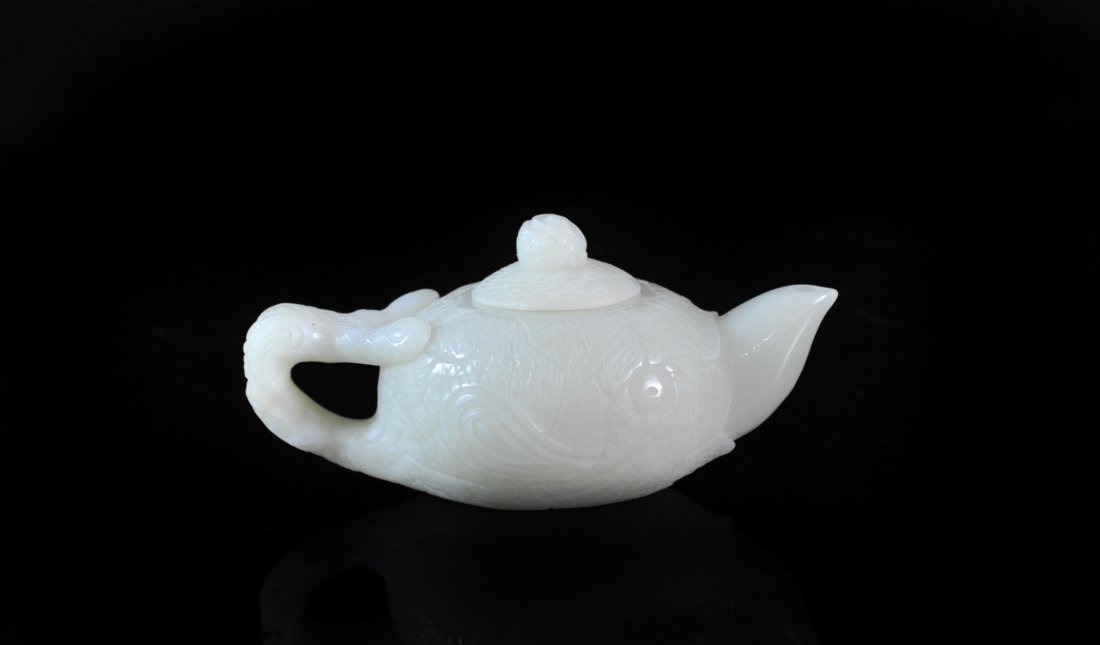 Chinese Hand Carved White Jade Tea Pot: DESCRIPTION: Chinese hand carved white jade tea pot beautifully carved features an elaborate floral design along the body, handle and lid. ORIGIN: China DIMENSIONS: H: 2" L: 4"