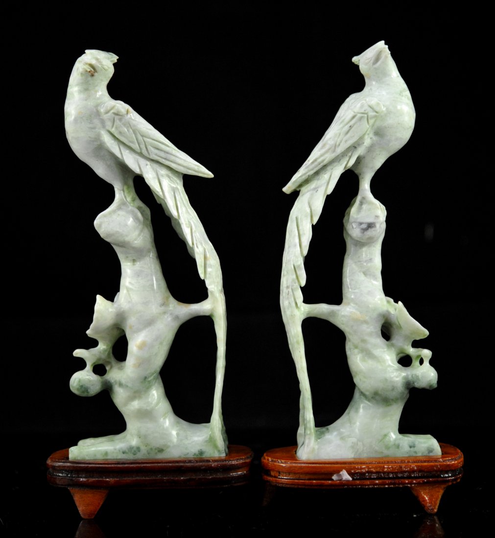 Pair of Vintage Creme Jade Carved Phoenix Birds: DESCRIPTION: Pair of vintage creme jade carved phoenix birds. Matching pair of mirrored hand carved green creme jade phoenix birds perched on thick branches adorned by foliage with hanging fruit. Come