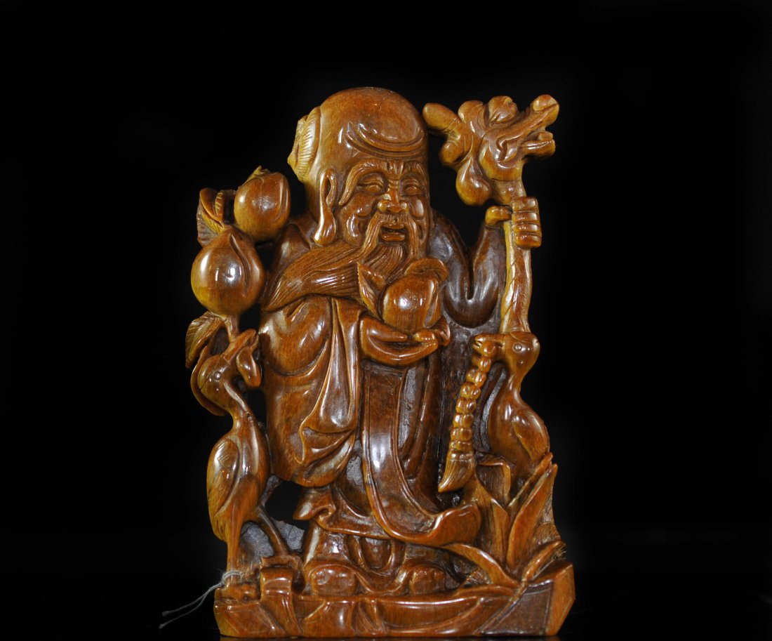 Early Chinese Hand Carved Tigers Eye Budha: DESCRIPTION: Early Chinese hand carved tigers eye figure on base. Depiction of an elderly bearded man holding a long beaded necklace with both hands with one foot on a tear drop jar tipped on it's sid