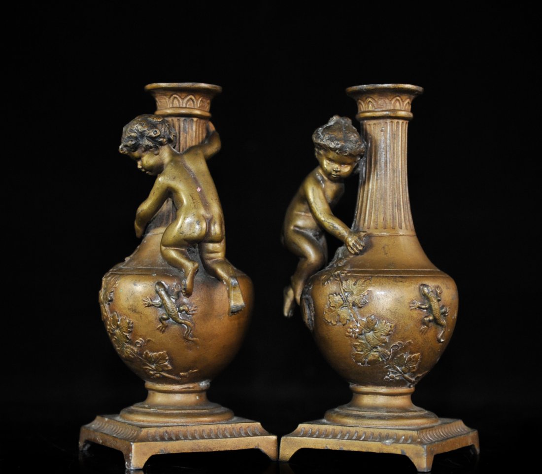 Pair Of Bronze French Candelsticks Signed: DESCRIPTION: Pair of bronze French candle sticks in tthe shape of a vase with cherubs hanging on the side and decorated with grapevines, a lizard and a beetle. Signed illegibly by artist on the back o