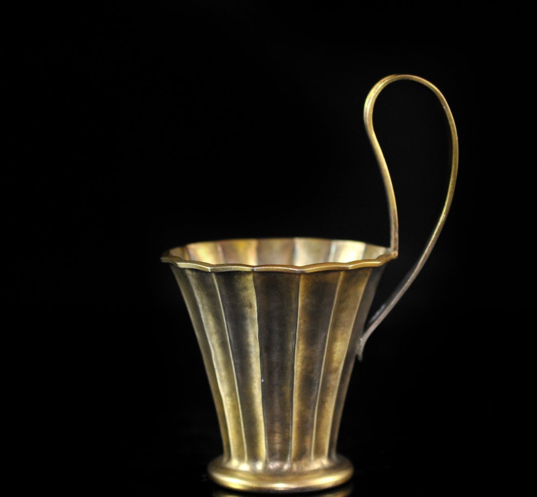 Lalaounis Gilted 900 Silver Cup: DESCRIPTION: Lalaounis Gilted 900 silver cup featuring an elongated handle. Body of the cup has smooth elegant design. Hallmarked "900 Lalaounis" CIRCA: 20th Ct. ORIGIN: Greece DIMENSIONS: H: 5.5" Dia