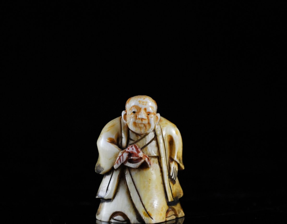 Japanese Signed Carved Ivory Netsukee: DESCRIPTION: Hand carved polychrome Japanese Ivory Netsuke dipicts an old man holding flowers. Signed in red characters on bottom. CIRCA: 20th Ct. ORIGIN: Japan DIMENSIONS: H: 1.5"