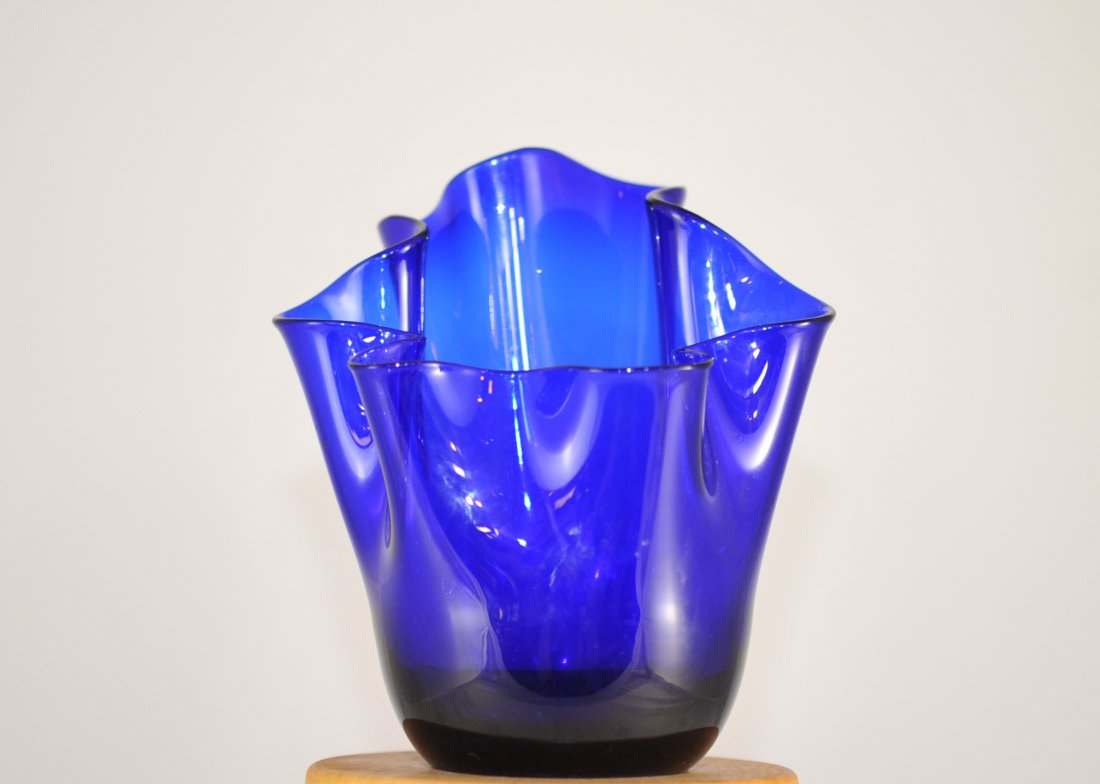 Versace Cobalt Blue Glass Vase: DESCRIPTION: Versace cobalt blue glass vase features multi-leveled folding edge. Inside bares the versace medusa head. CIRCA: Late 20th Ct. ORIGIN: Italy DIMENSIONS: H: 6.5" L: 5"