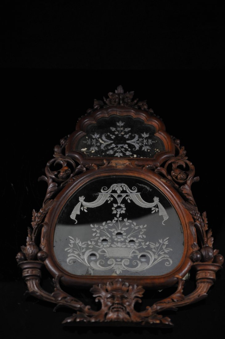 Hand Carved Mythological Double Wooden Mirror: DESCRIPTION: Double mirror design nestled in a double wooden frame. Intricately carved leaf and vine design around the border. Mythological face at the base of the mirror. The entire wooden frame is h