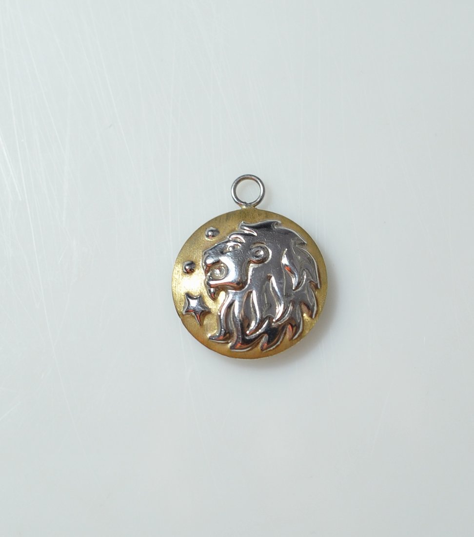 Italian 18Kt Lion Pendant: DESCRIPTION: Italian two tone white and yellow 18 karat gold pendant featuring a lion's head design on the front. Hallmarked on the back "OTC" "18kt" and "Italy" on the back. Weighs a total of 4.4 gra