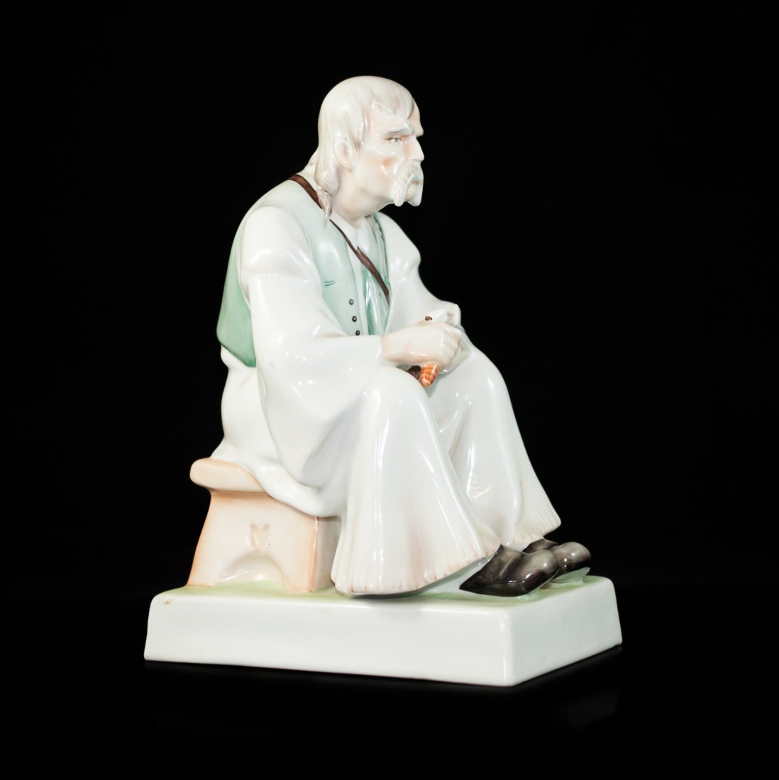 Zsolnay Woodcarver Porcelain Figurine: DESCRIPTION: Zsolnay pecs multicolored handpainted porcelain figurine features a older man carving wood. Marked on the bottom "Pecs". CIRCA: 20th Ct. ORIGIN: Hungary DIMENSIONS: H:11.5" L: 8.5"