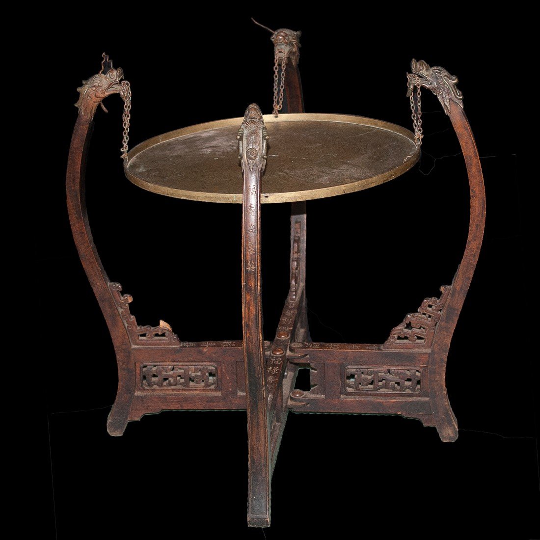 Chinese Brass & Wood Table: DESCRIPTION: Chinese wood table features detailed carvings of floral and village throughout the body. The table stands on four legs decorated with bronze dragon heads atop each corner. Together each f
