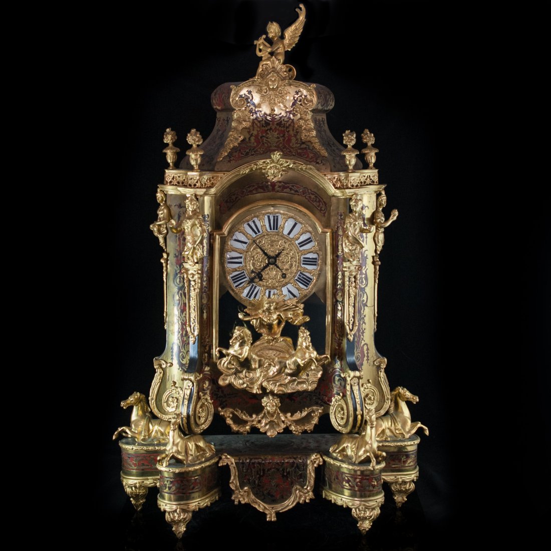 Gilt Bronze Boulle Clock: DESCRIPTION: A finely crafted wooden boulle clock with gilted bronze designs and figures. At the top of the clock rests a figure of an angel holding a harp. The sides of the clock are inlayed and ador
