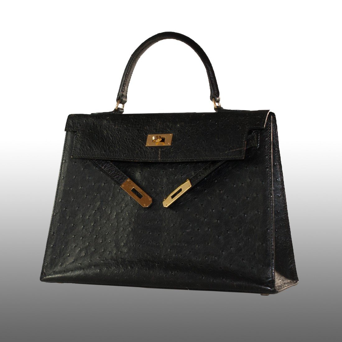 Hermes Kelly Bag: DESCRIPTION: A black leather purse designed by the famous Hermès company. Named after the beautiful Grace Kelly, this vintage "Kelly Bag" design is still trending in today's fashion. The lock straps 