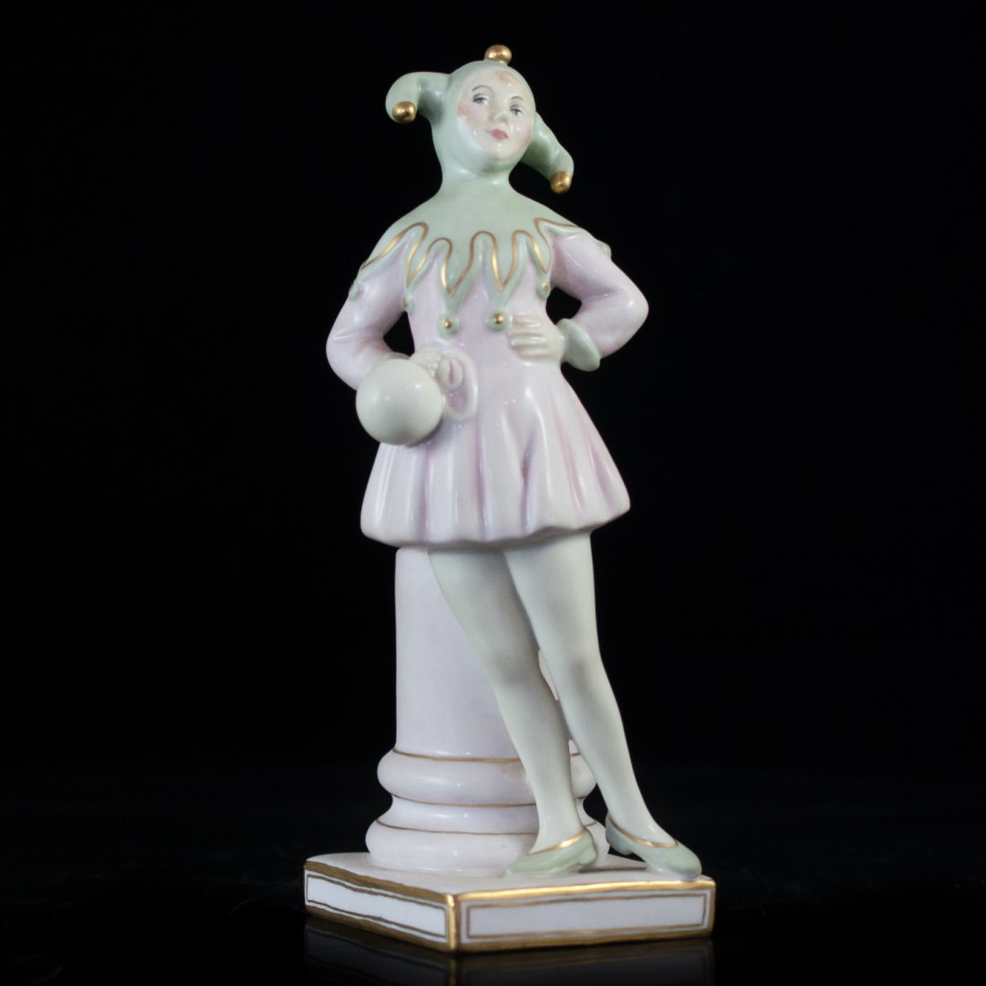 Royal Doulton "Lady Jester": DESCRIPTION: Royal Doulton Porcelain figurine titled "Lady Jester" depicted standing. The Jester is painted in pink and green finished with gilded accents. Marked on the bottom " Royal Doulton The Jes