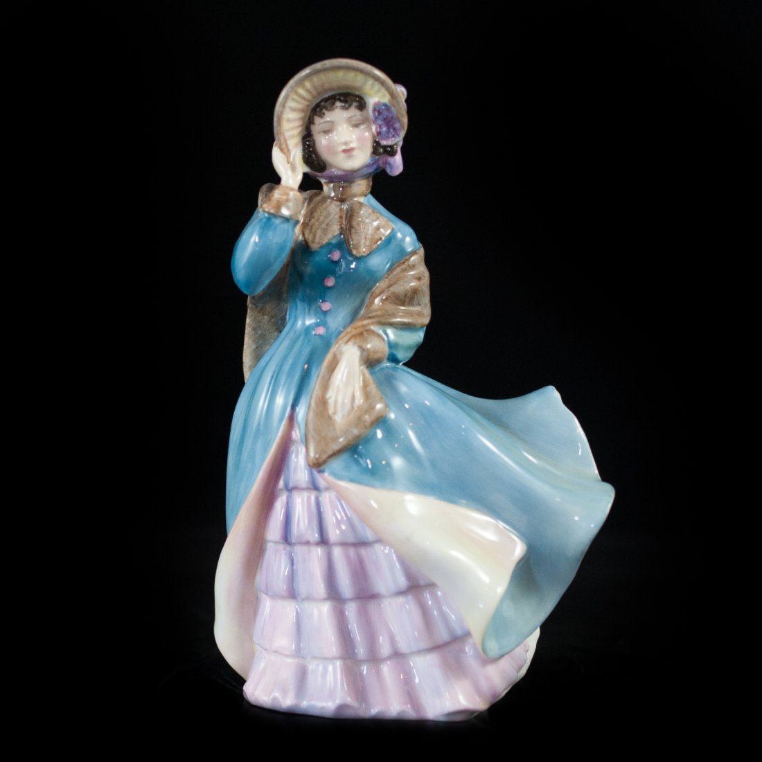 Royal Doulton "Delphine": DESCRIPTION: Titled "Delphine". A high glossed, hand created and painted bone china figurine of a woman wearing pink attire with a blue coat. Designed by M. Davies and issued from 1954 to 1967. CIRCA: