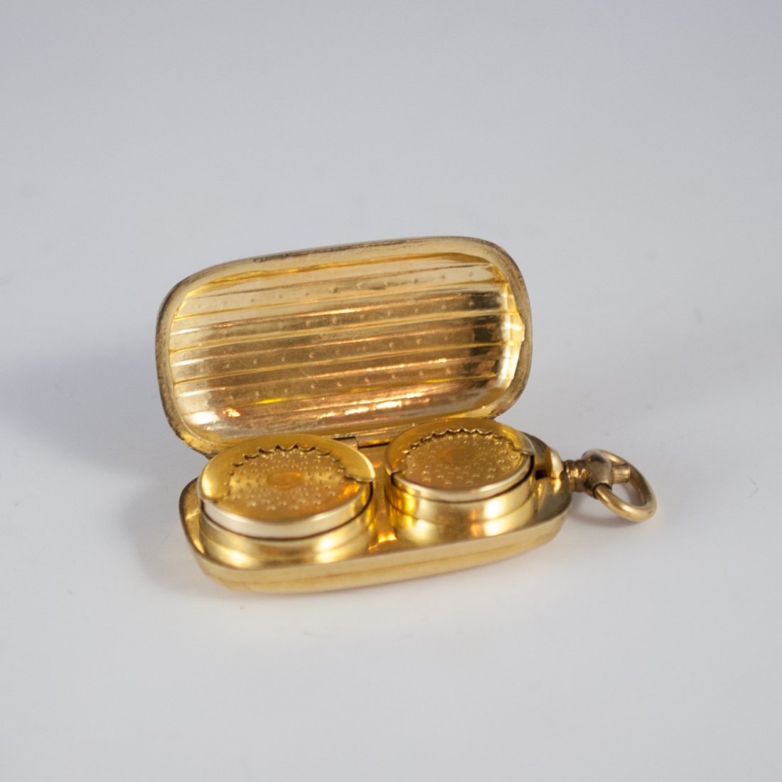 Gold Coin Case: DESCRIPTION: 18k gold plated coin case features a a art deco style design. The case open with a push button revealing a dime and nickle holder inside. CIRCA: 20th Ct. ORIGIN: USA DIMENSIONS: L: 2.5" H