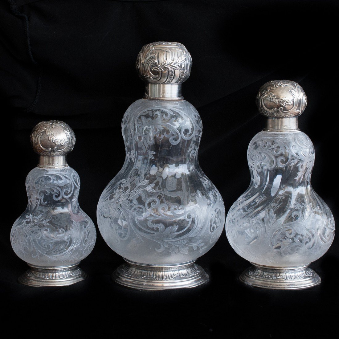 Sormani Sterling & Glass Decanters: DESCRIPTION: Three genuine Sormani silver and etched glass vintage decanters of differing sizes. Stunning sterling silver lid reveals glass stopper. Etched glass carafe features wonderfully etched gla