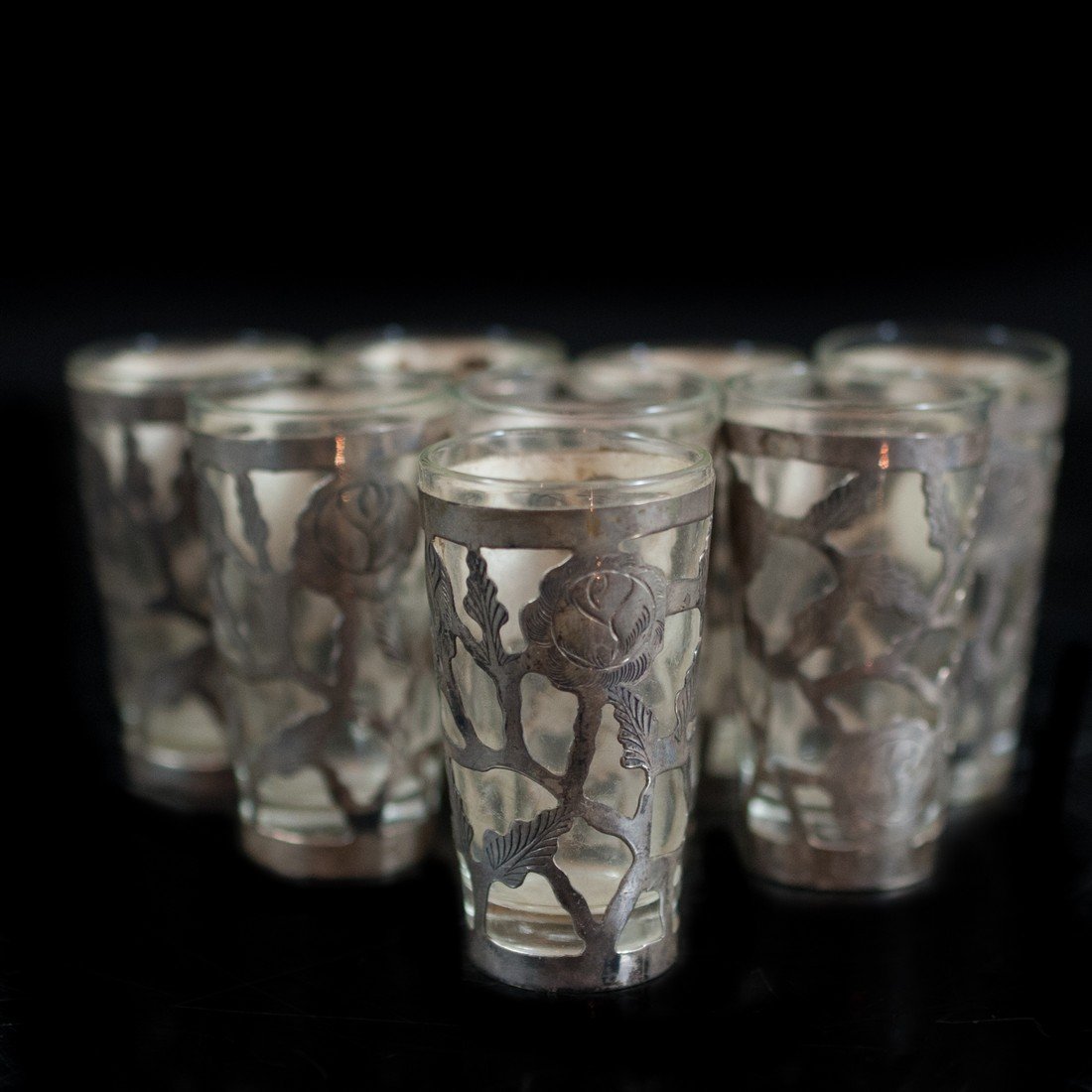 Set of Sterling & Glass Shot Glasses: DESCRIPTION:Set of eight sterling and glass shot glasses. Finished with floral sterling overlay. Marked on bottom: "Hecho en Mexico" S.A.R. INC." CIRCA:20th Ct. ORIGIN:Mexico DIMENSIONS:H: 3" Diameter