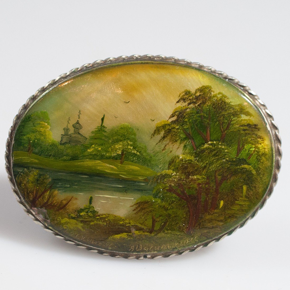 Sterling Silver & Enamel Pendant: DESCRIPTION: Sterling silver handpainted enamel featuring a scenic landscape depiction in hues of green, yellow, and blue. Encompassed by a braided sterling silver border. Signed in Russian: "A Vaseli