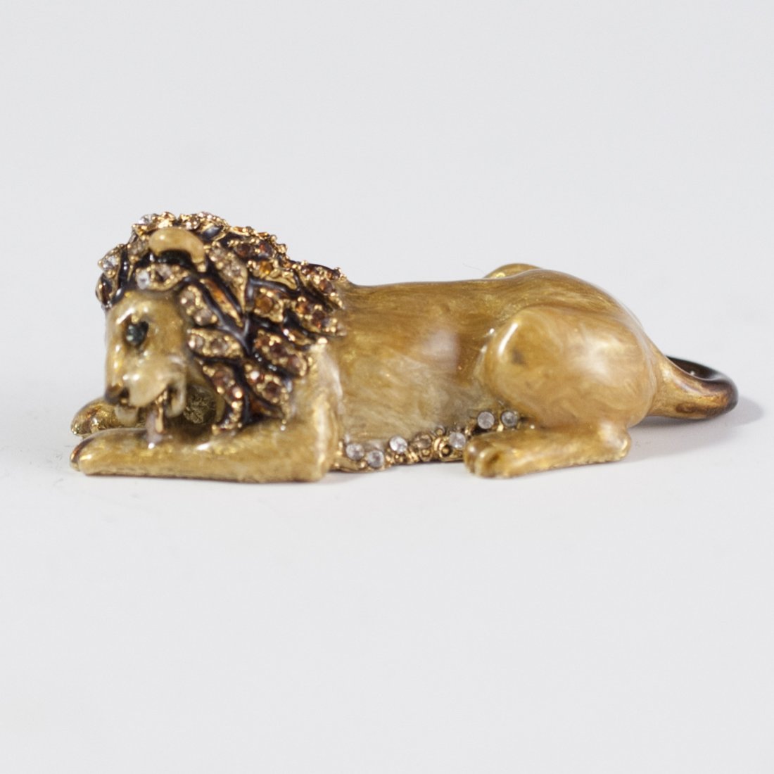 Jay Strongwater Lion Figurine: DESCRIPTION:Jay Strongwater hand enameled figurine of a regal lion licking his paw. Finished in a caramel gloss enamel and garnished with hand set Swarovski crystals along the body, mane, and tail. In