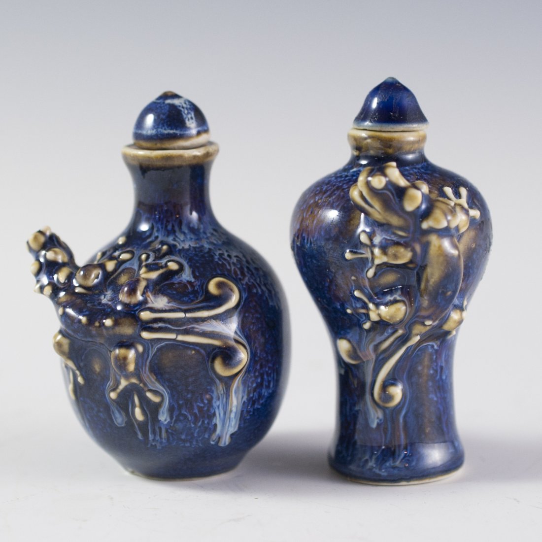 Pair of Cobalt Blue Lizard Snuff Bottles: DESCRIPTION:Pair of handpainted cobalt blue porcelain snuff bottles. Features lizard figurines hanging off the edges of the snuff bottle. Finished with corked lids. CIRCA:20th Ct. ORIGIN:China DIMENSI