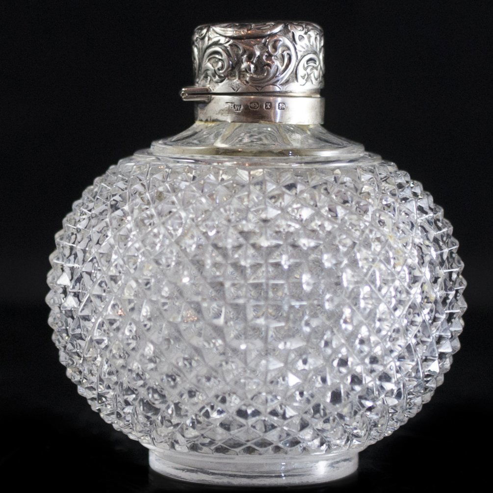 William Harrison Walter Sterling & Glass Perfume Bottle: DESCRIPTION:William Harrison Walter perfume bottle. Comprises of a spherical crystal cut glass body finished with a hinged sterling lid adorned with paisley designs that opens to reveal small frosted